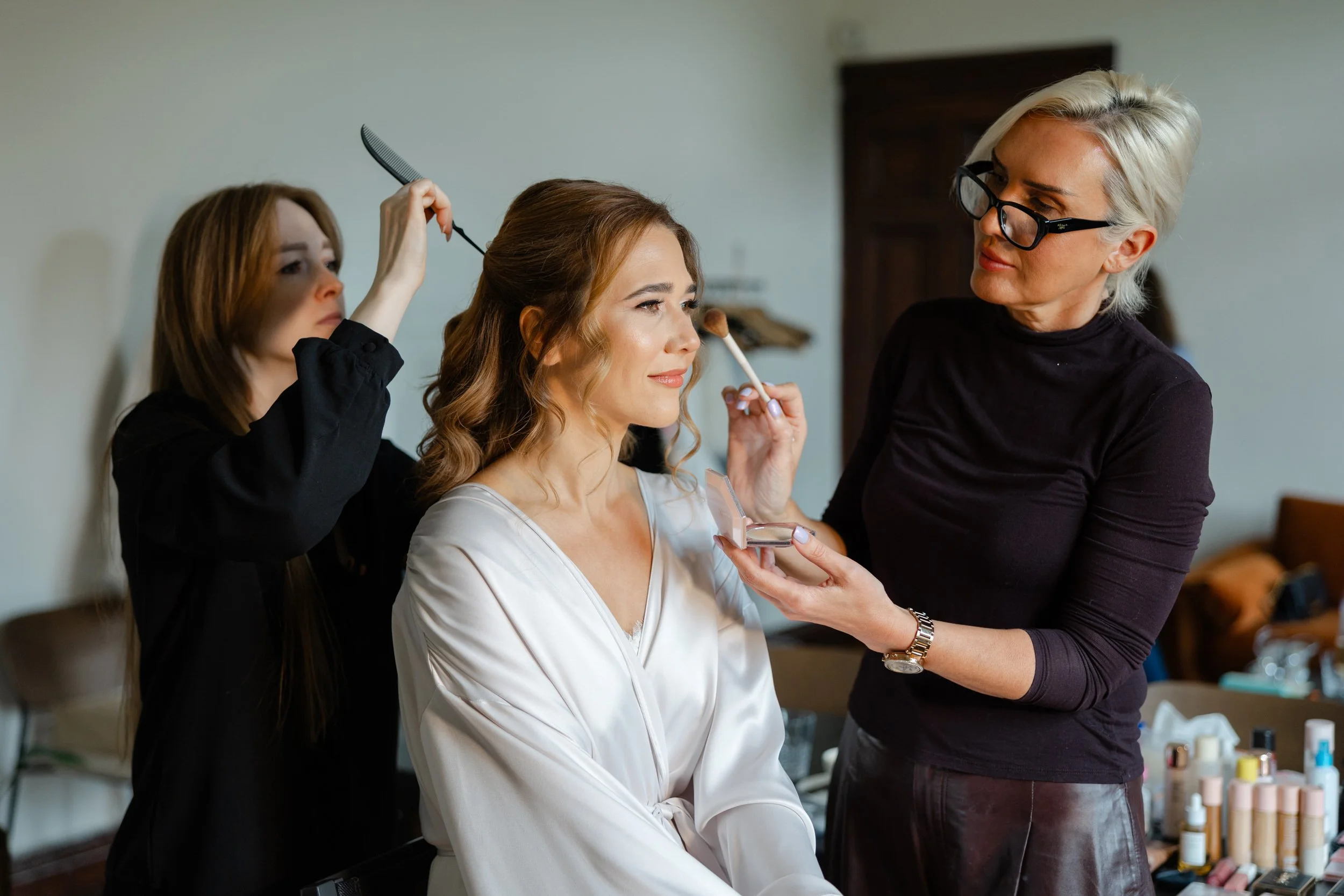   Make-up voorbereidingen van de bruid in een ontspannen setting voorafgaand aan de ceremonie  