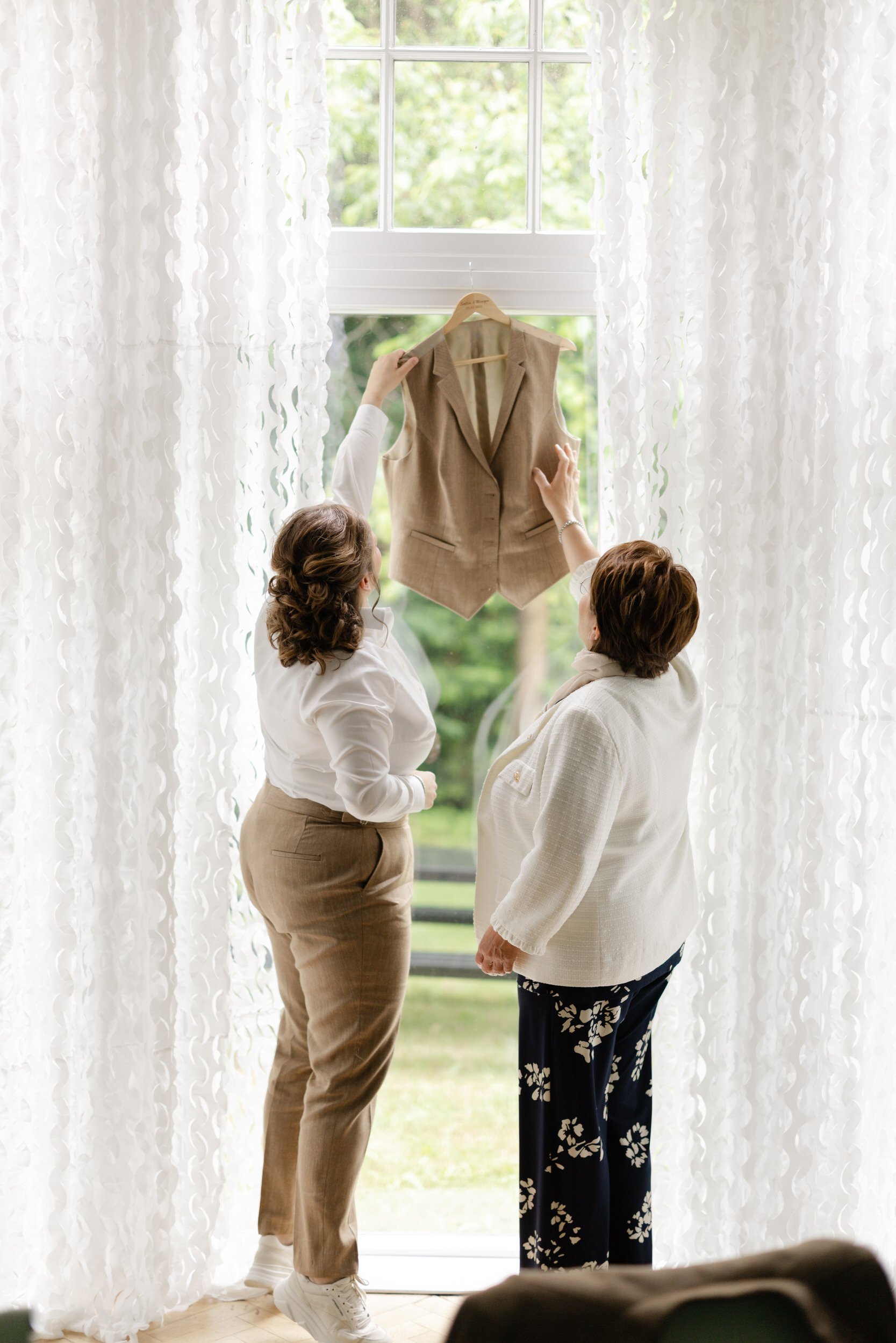   Evelien haalt samen met haar moeder het bruidsgilet eraf, tijdens de get ready bij Villa Klein Heumen  