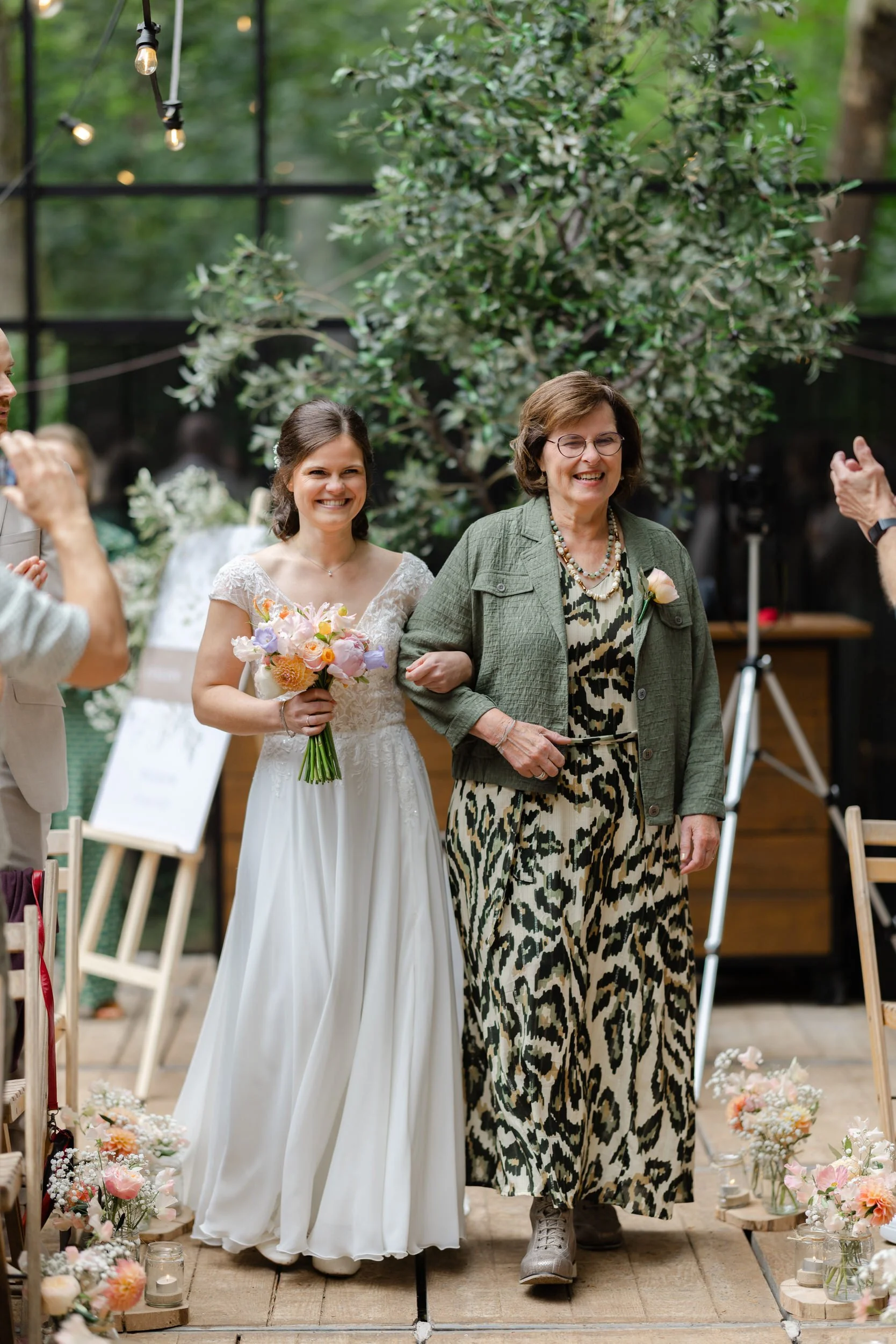   Monique loopt samen met haar moeder naar de ceremonie in de glazen boskas bij Villa Klein Heumen  