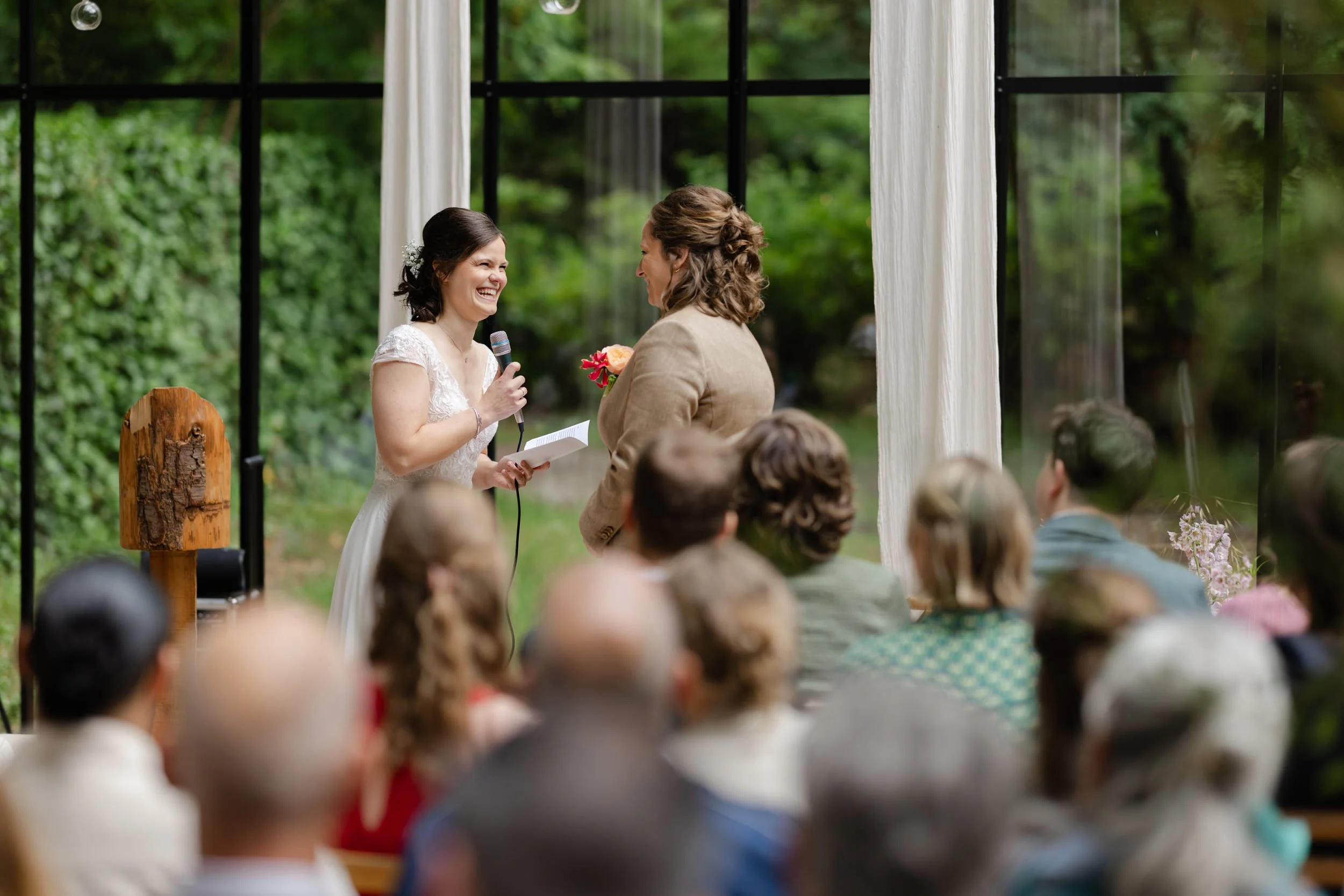   Monique spreekt Evelien toe tijdens de ceremonie in de glazen boskas bij Villa Klein Heumen  