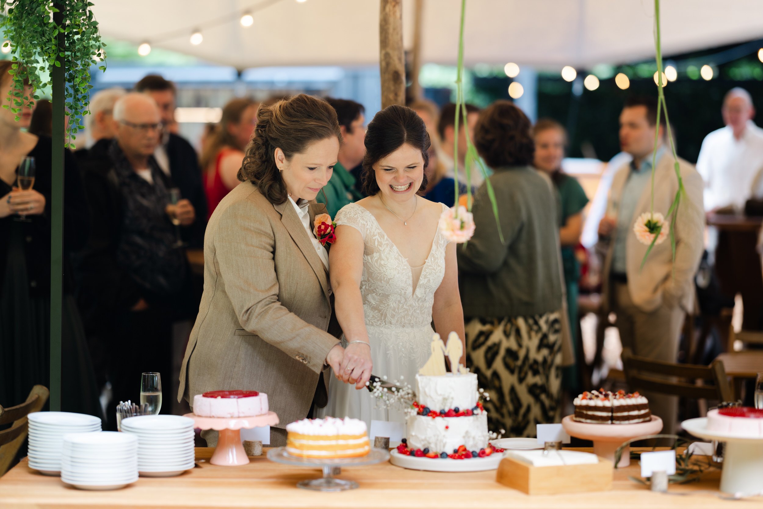   Evelien en Monique snijden samen hun bruidstaart aan tijdens de receptie bij Villa Klein Heumen  