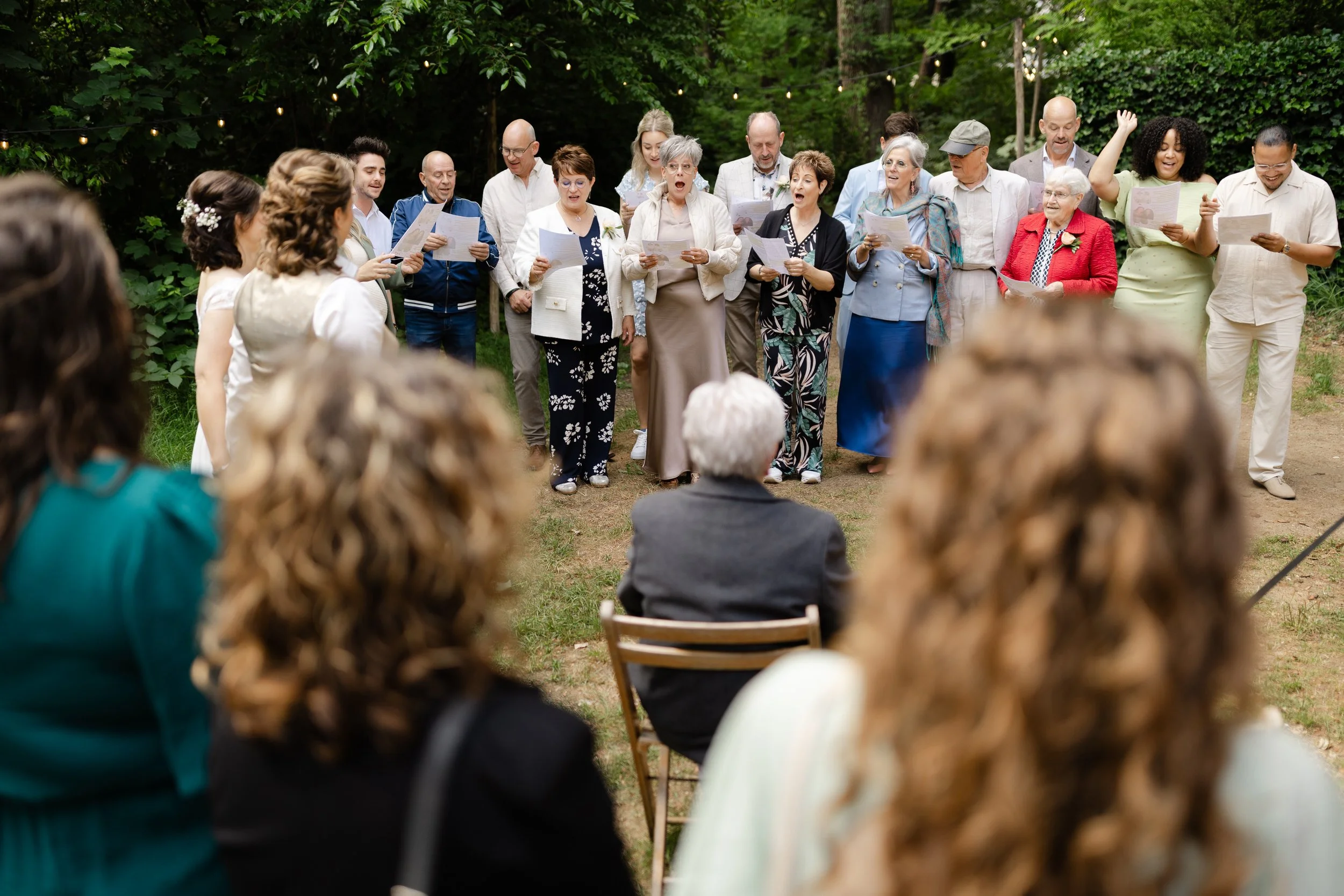   Gasten zingen samen tijdens de ceremonie van Evelien en Monique bij Villa Klein Heumen  