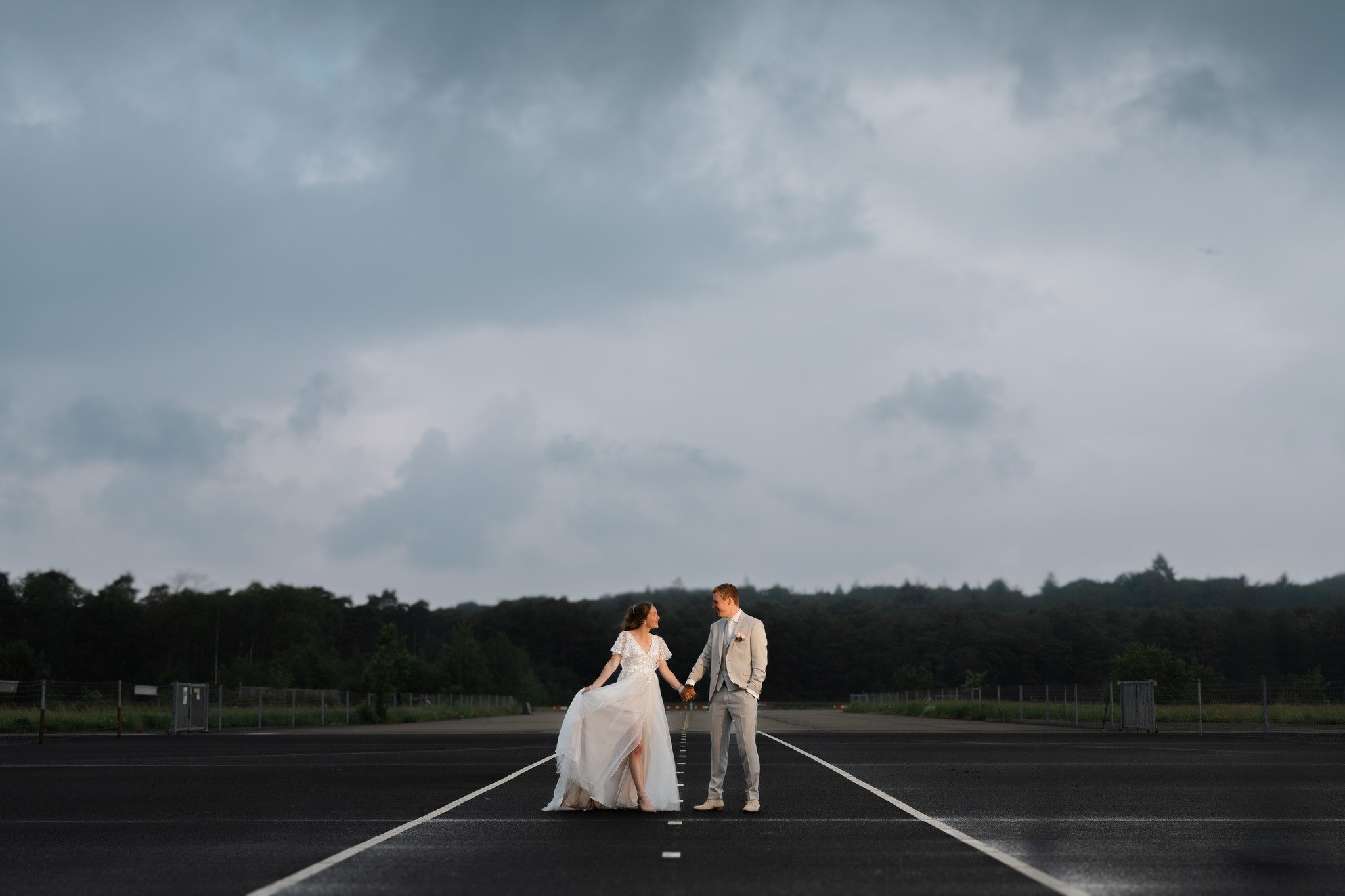 Daan &amp; Lineke tijdens hun fotoshoot bij Vliegbasis Soesterberg, vastgelegd in een editorial beeld, precies vlak voordat het begon te regenen. Just in time!!

Daan: @daanvisser 
Lineke: @linekeschelhaas 
Bruidsjurk: @hetwittehuysbruidsmode 
Pak: @