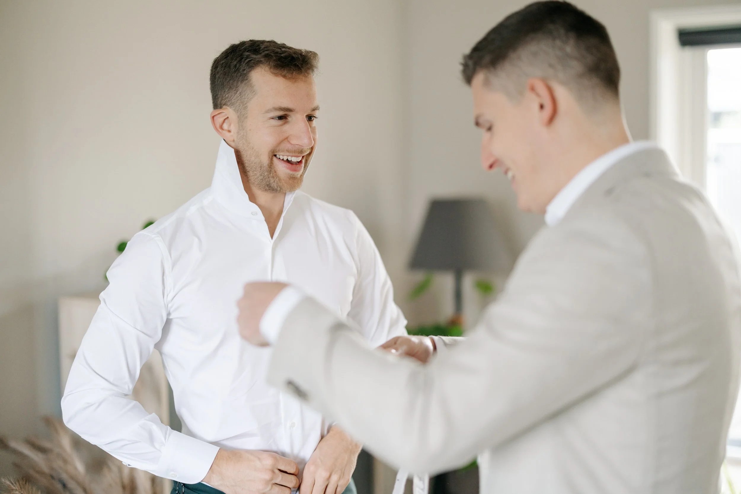   Vriend helpt Mike met zijn overhemd tijdens de voorbereiding thuis    