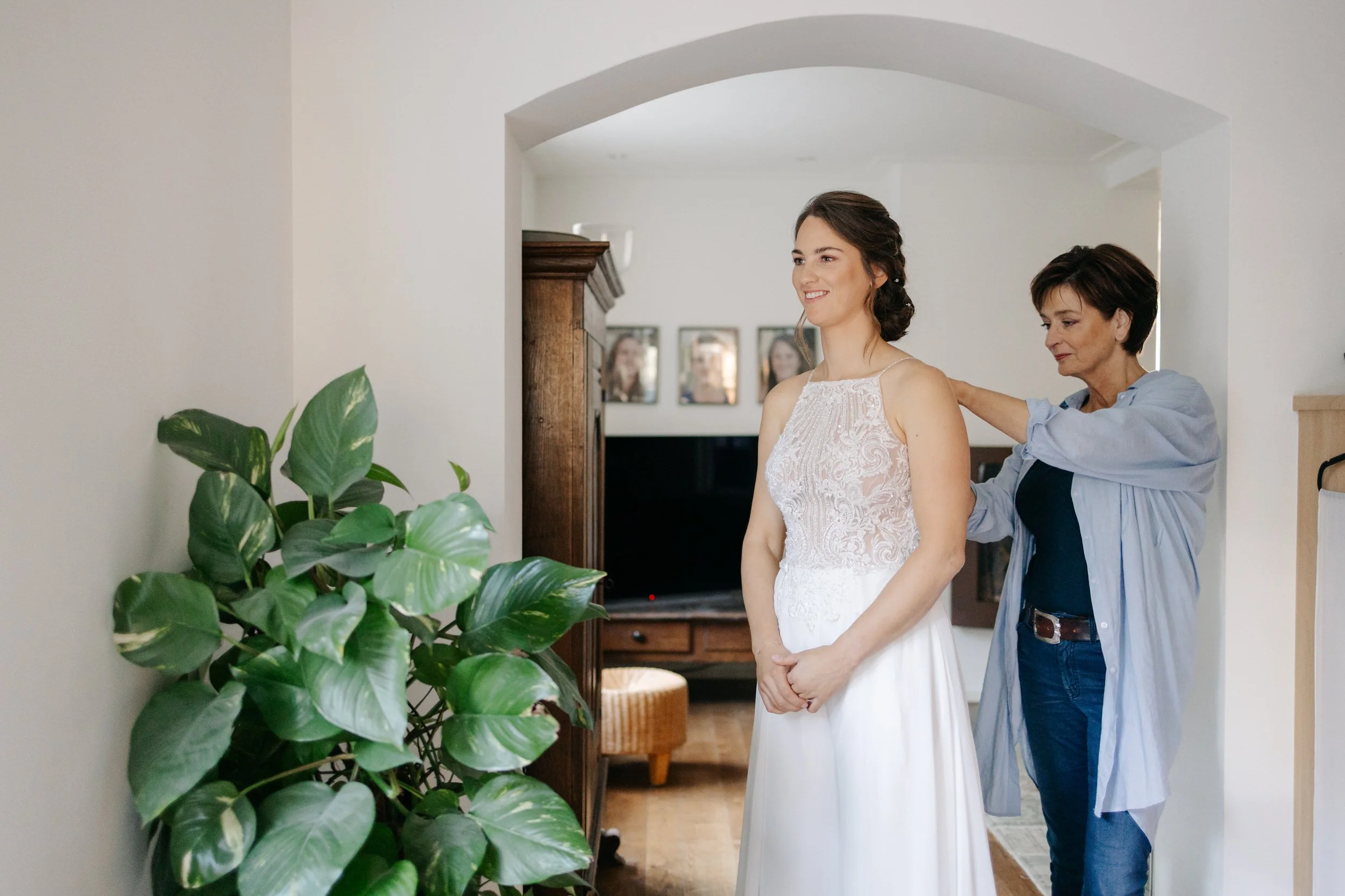   Roos wordt geholpen met het aantrekken van haar trouwjurk tijdens de voorbereidingen    