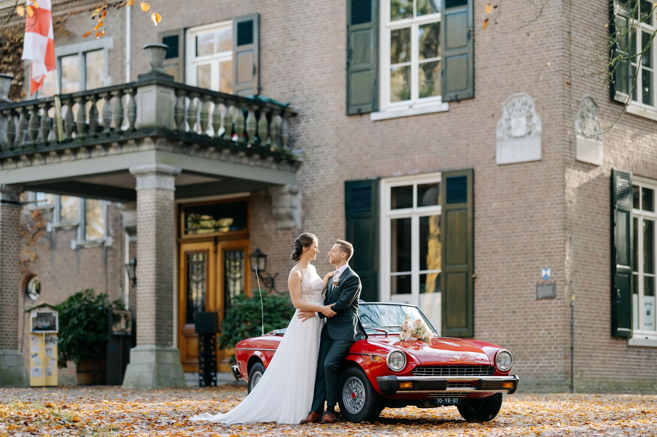   Mike en Roos bij de rode auto voor Kasteelhoeve Geldrop in Geldrop (Noord-Brabant)    