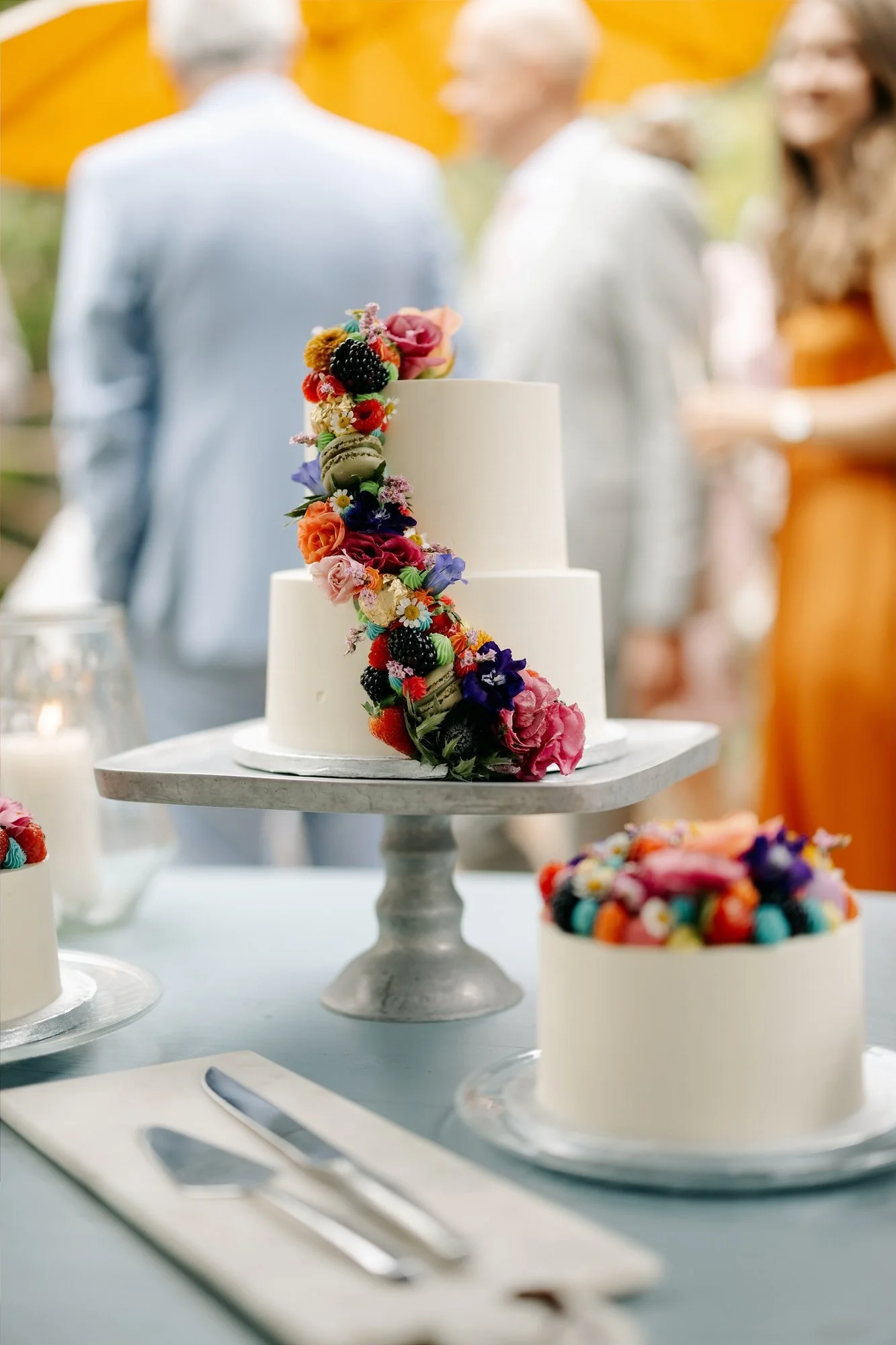  Witte bruidstaart met kleurrijke bloemen en macarons op de trouwdag 