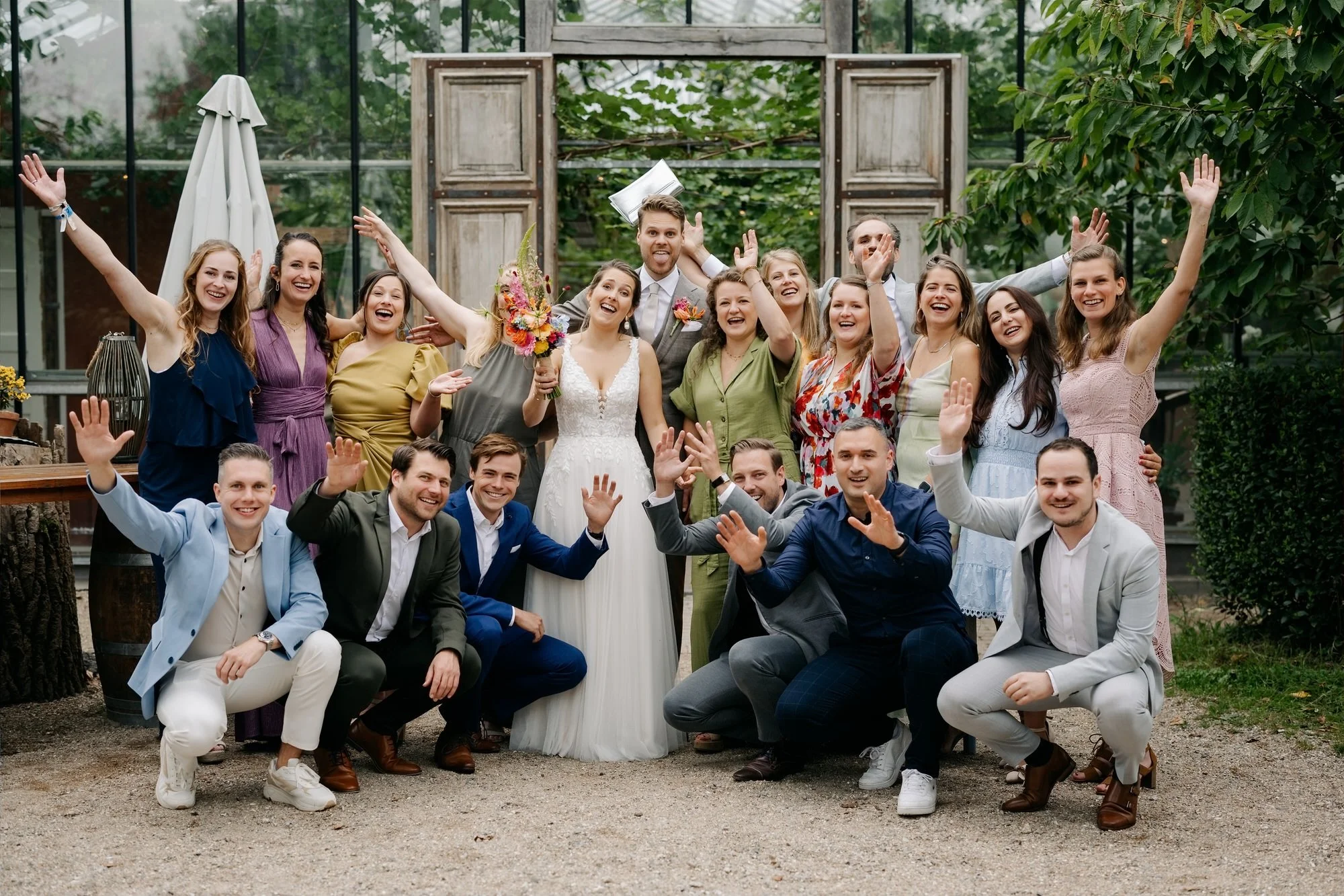  Groepsfoto van alle vrienden voor de houten deuren van de glazen kas 