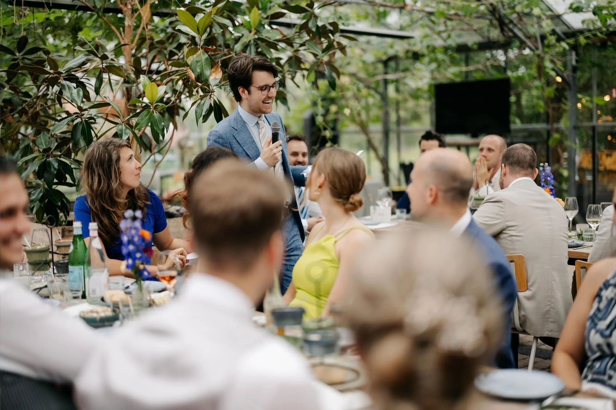  Gast houdt een speech tijdens het diner in de glazen kas 