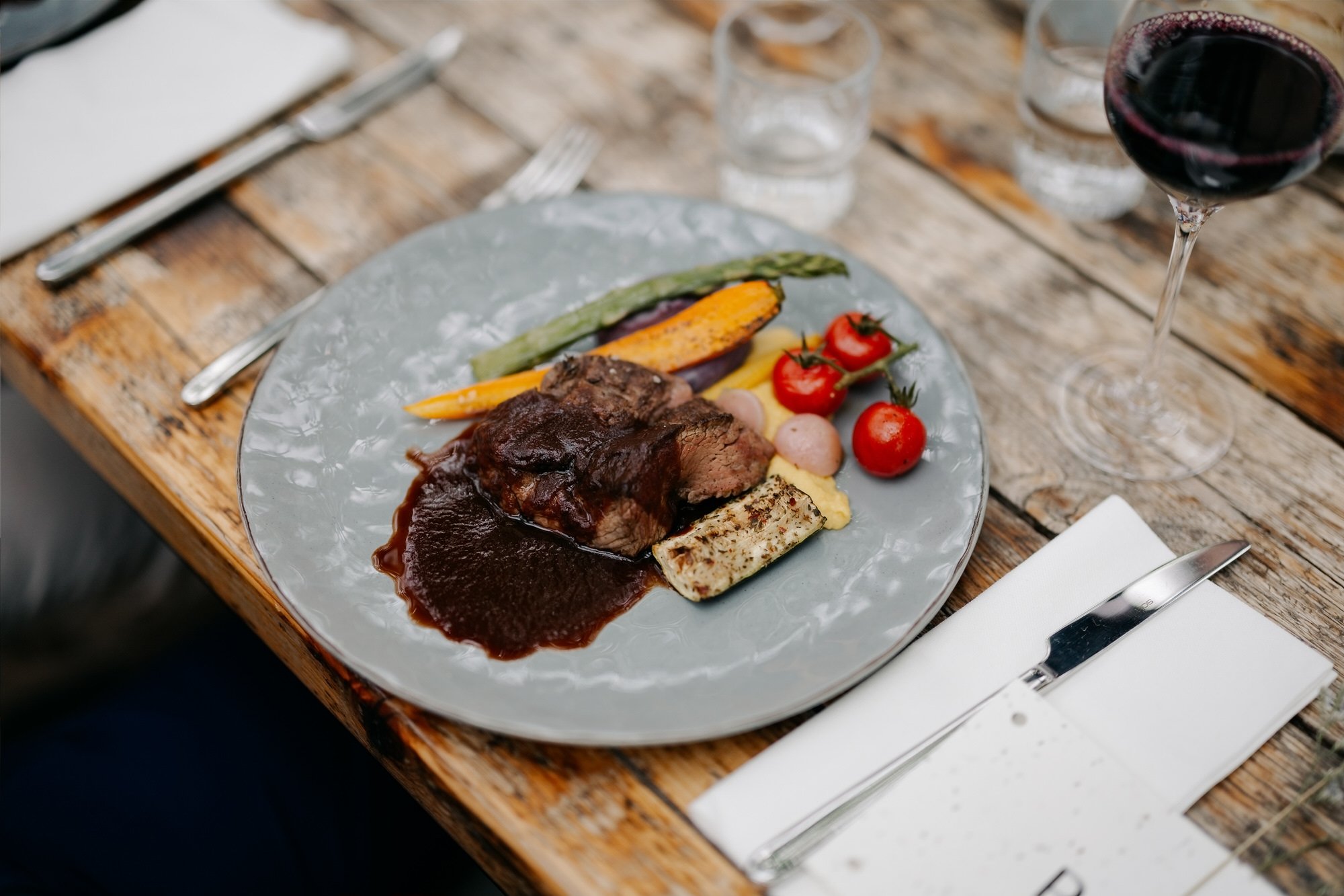  Hoofdgerecht vlees met groenten en rode wijn tijdens het bruiloftsdiner 