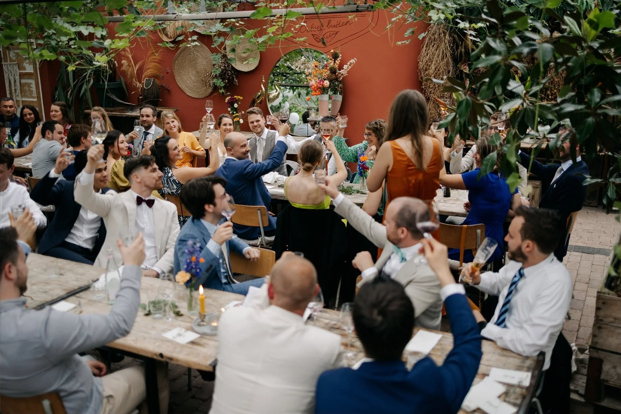  Alle gasten heffen het glas tijdens een toast in de glazen kas 