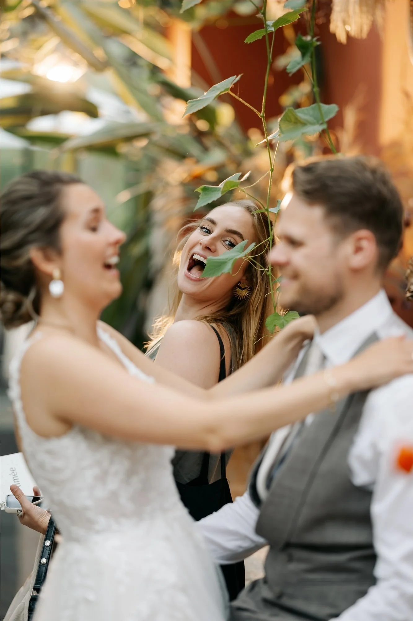  Gast lacht uitbundig met het bruidspaar tijdens de avond shoot  