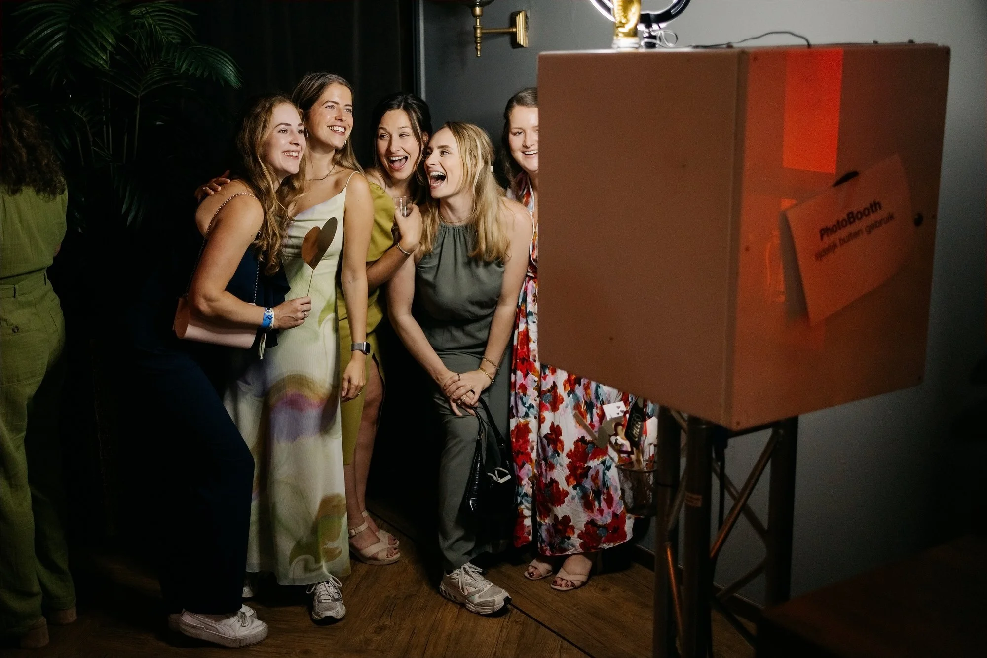  Vriendinnen poseren lachend voor de photobooth tijdens de feestavond 