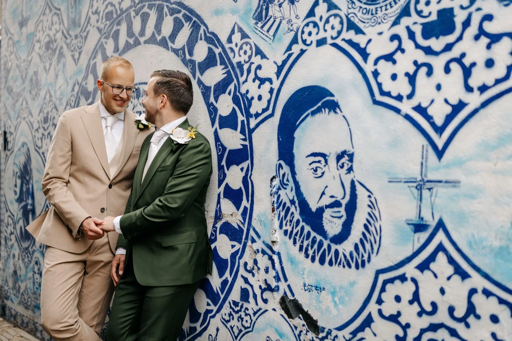  Bruidegoms poseren voor een Delfts blauw tegeltableau 