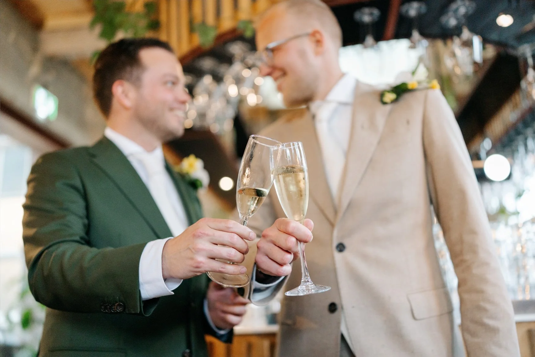  Bruidegoms proosten met champagne, lachend naar elkaar 