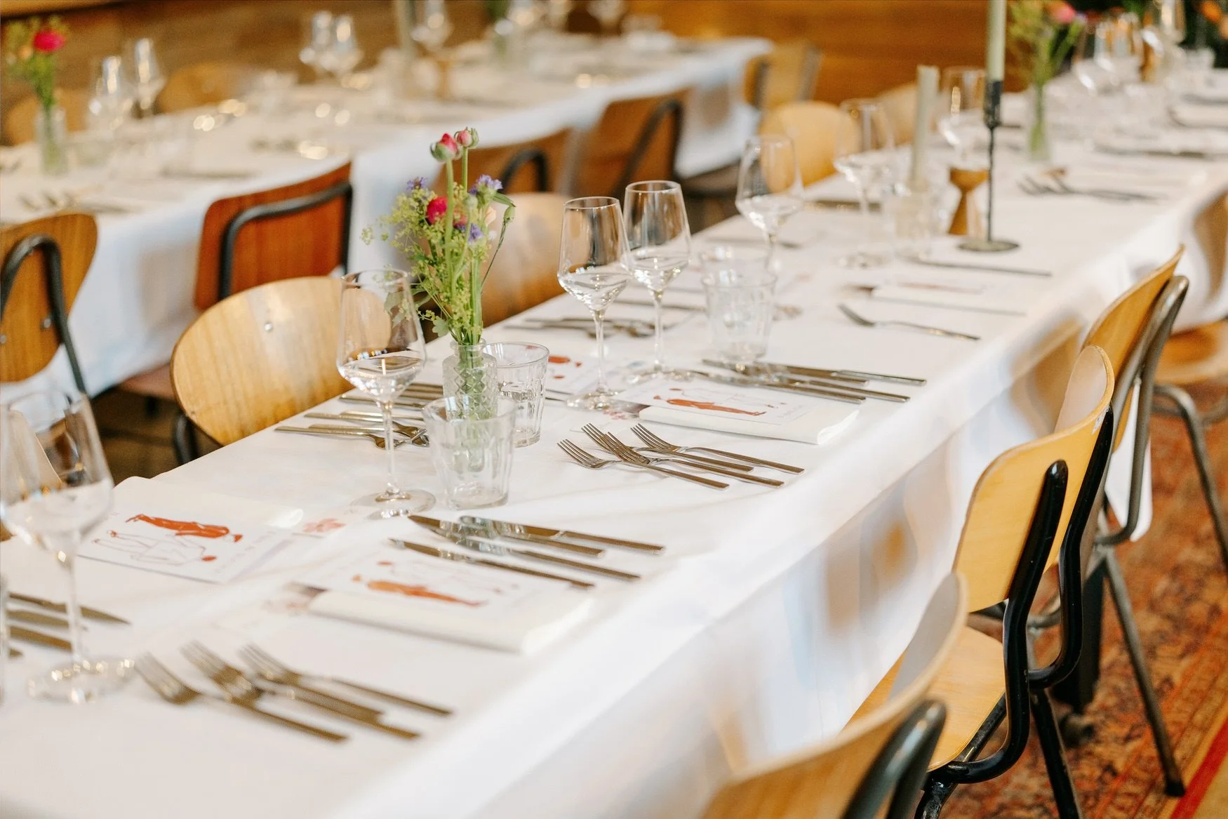  Feestelijk gedekte lange tafel met witte kleden en kaarsen 