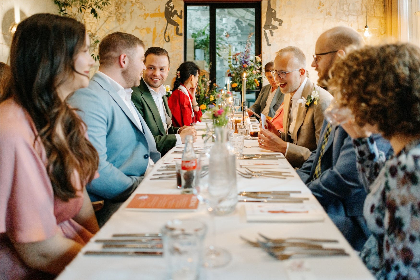  Gasten en bruidegom aan tafel in gesprek tijdens het diner 