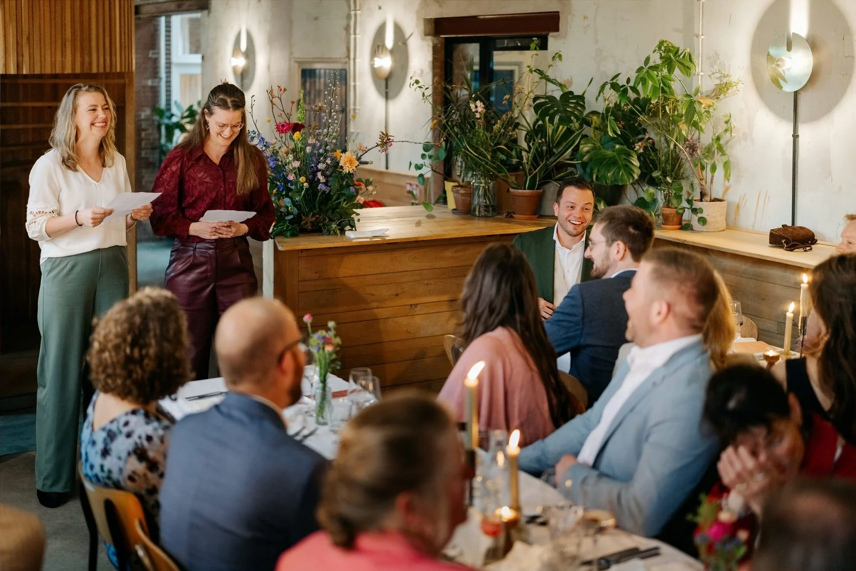  Gast houdt een speech voor de zittende tafelgasten in het restaurant 