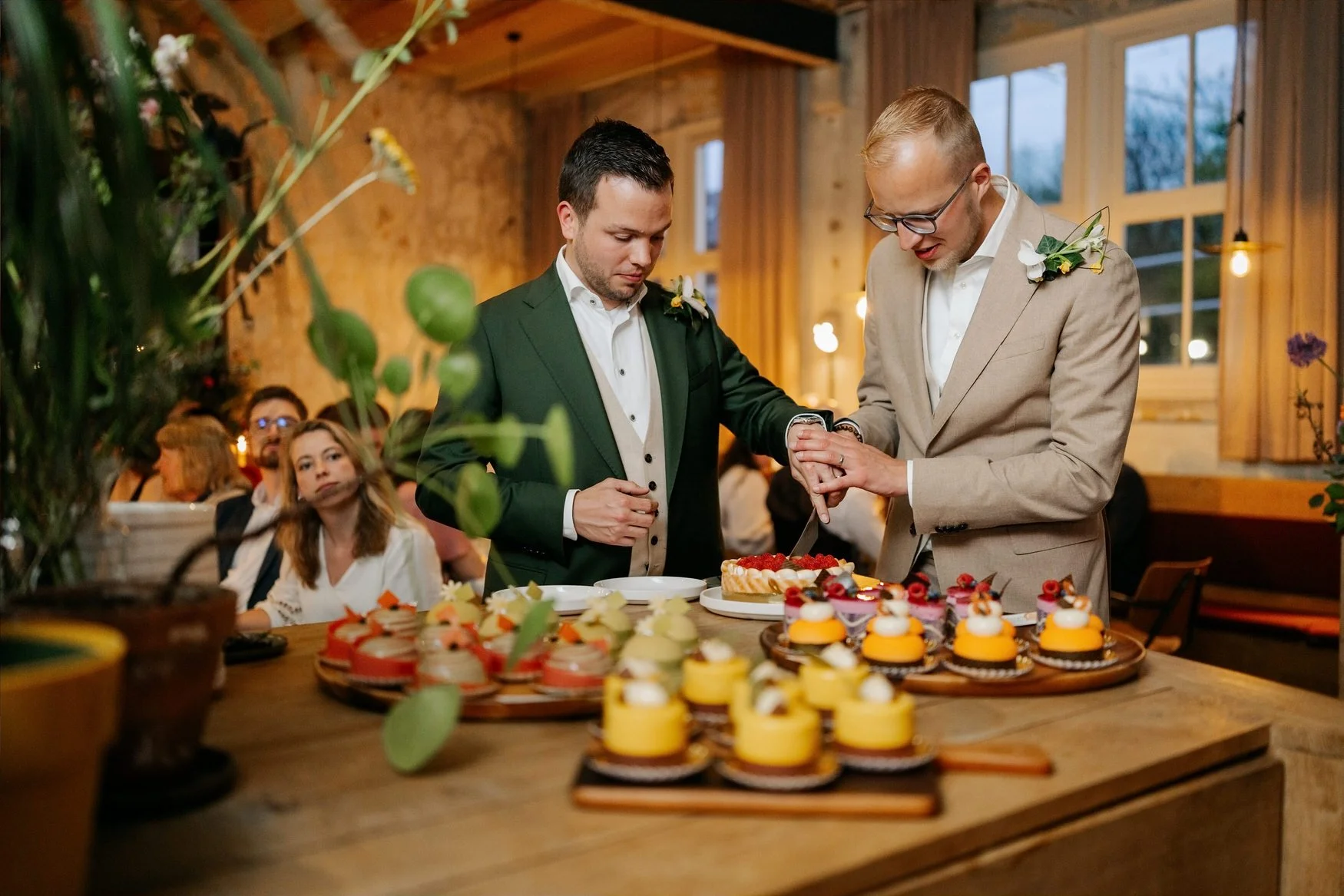  Bruidegoms snijden samen de bruidstaart aan 