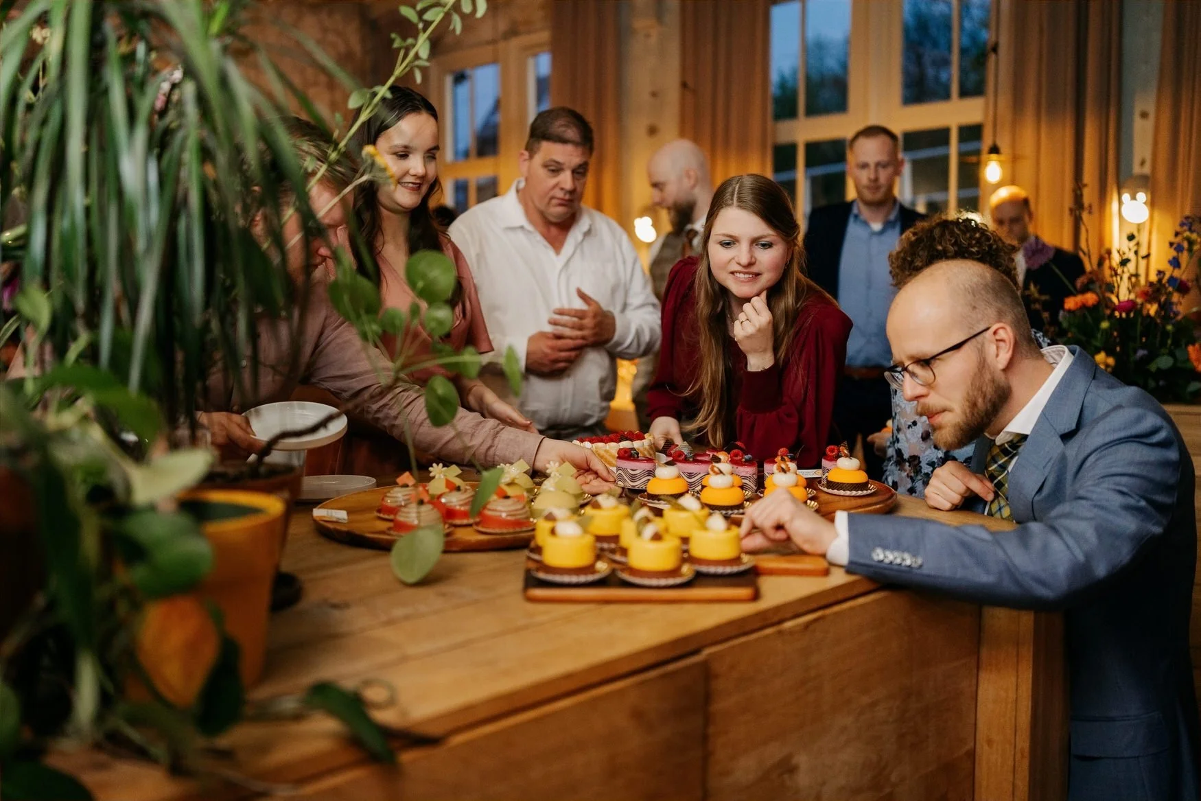  Gasten verzamelen zich rond de dessertbar met gele taartjes 