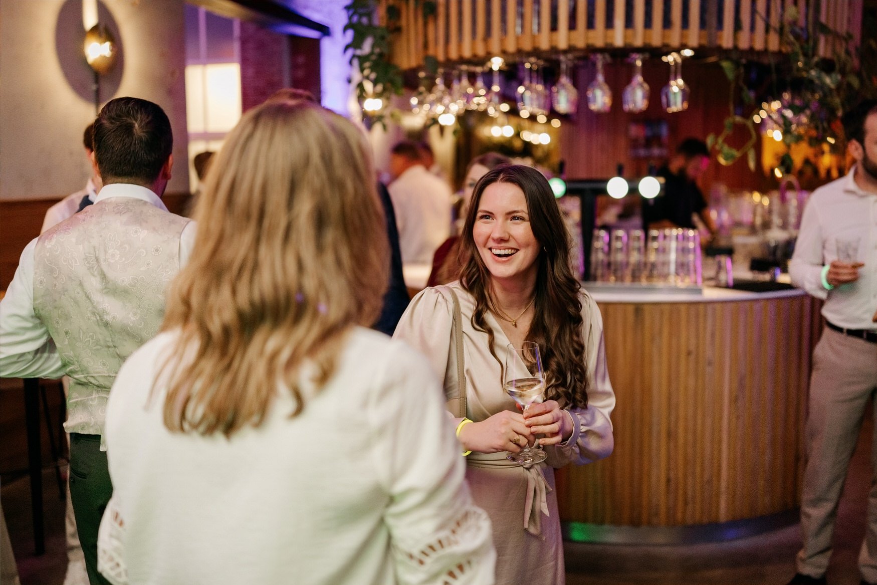  Gasten kletsen en lachen bij de bar tijdens het feest 