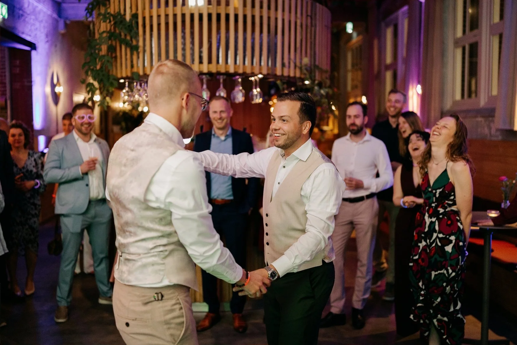  Bruidegoms dansen samen op de dansvloer omringd door gasten 