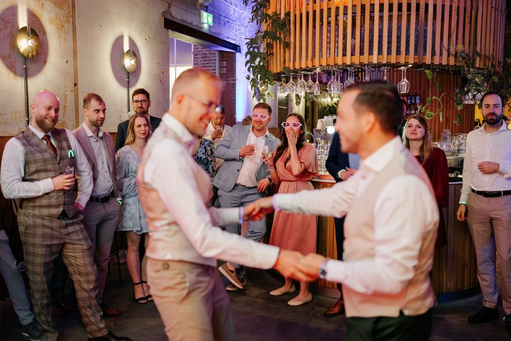  Bruidegoms dansen uitgelaten terwijl gasten toekijken 