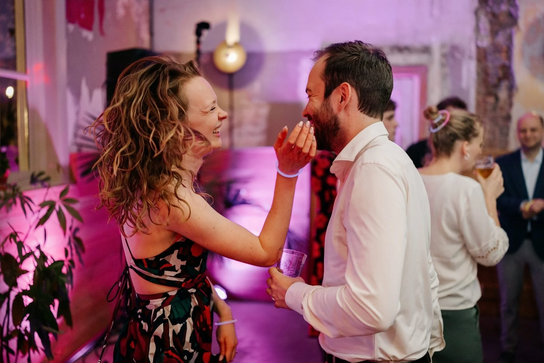  Gasten dansen dicht bij elkaar in paars gekleurd licht 