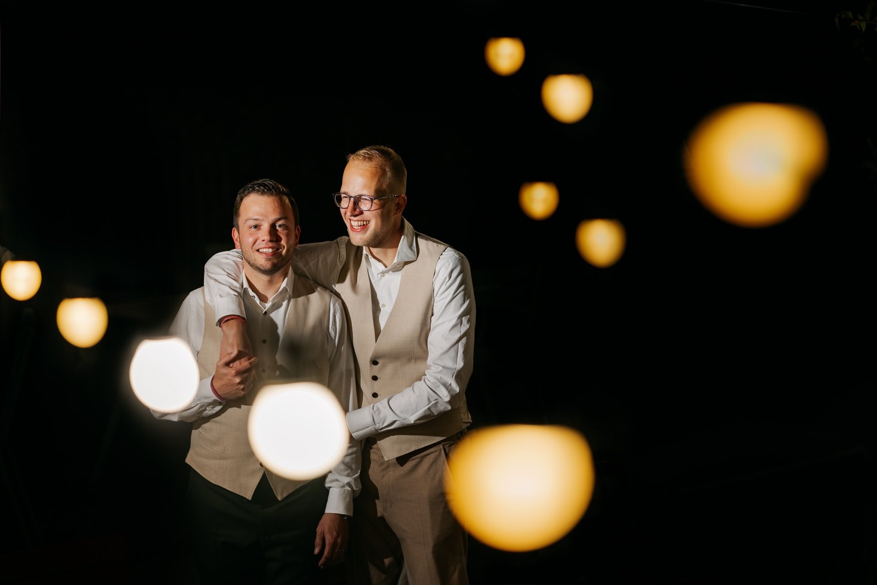 Het bruidspaar staat in creatief licht als afsluiter van de avond voor de fotograaf