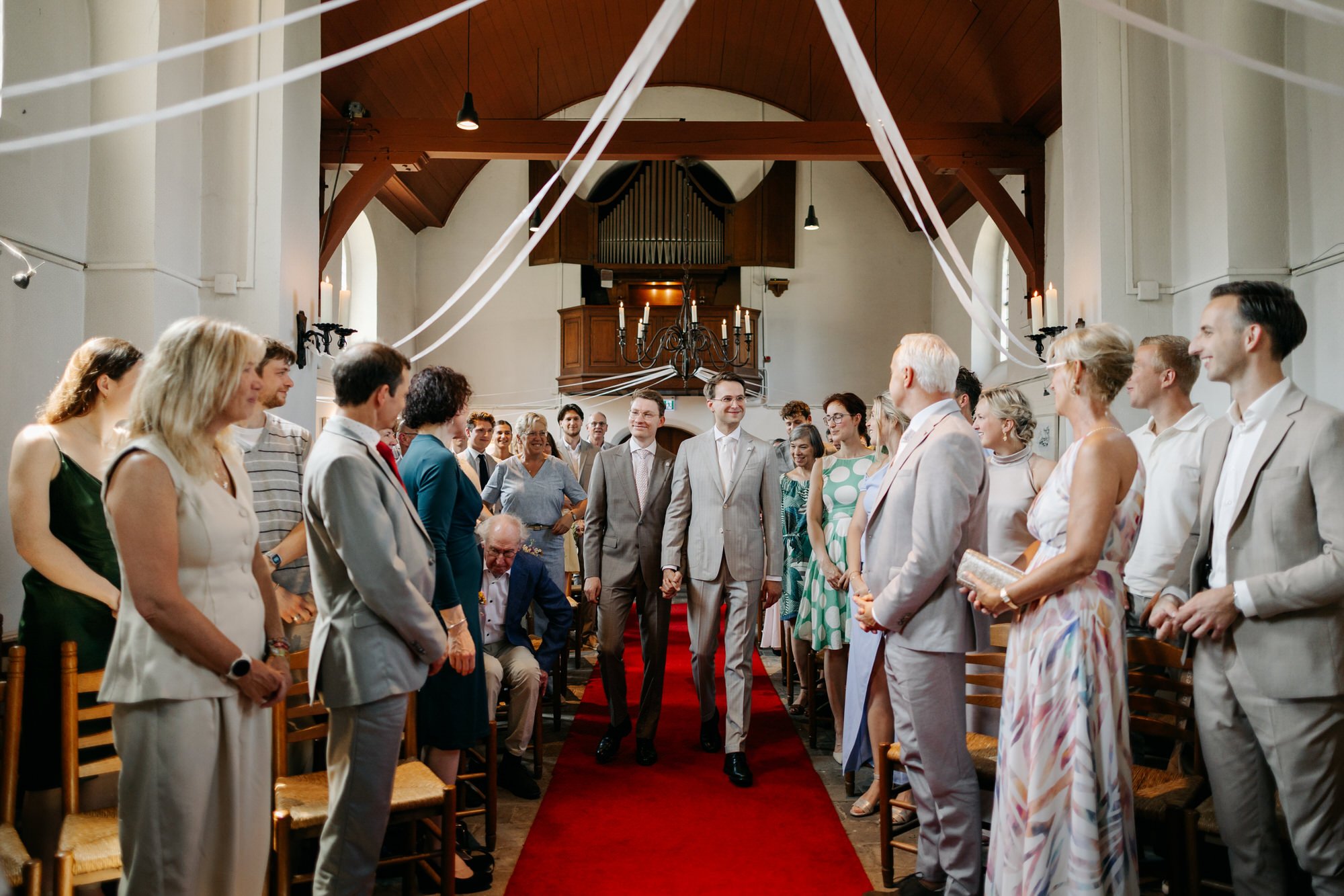  bruidegoms lopen het Pieterskerkje binnen tijdens de ceremonie 