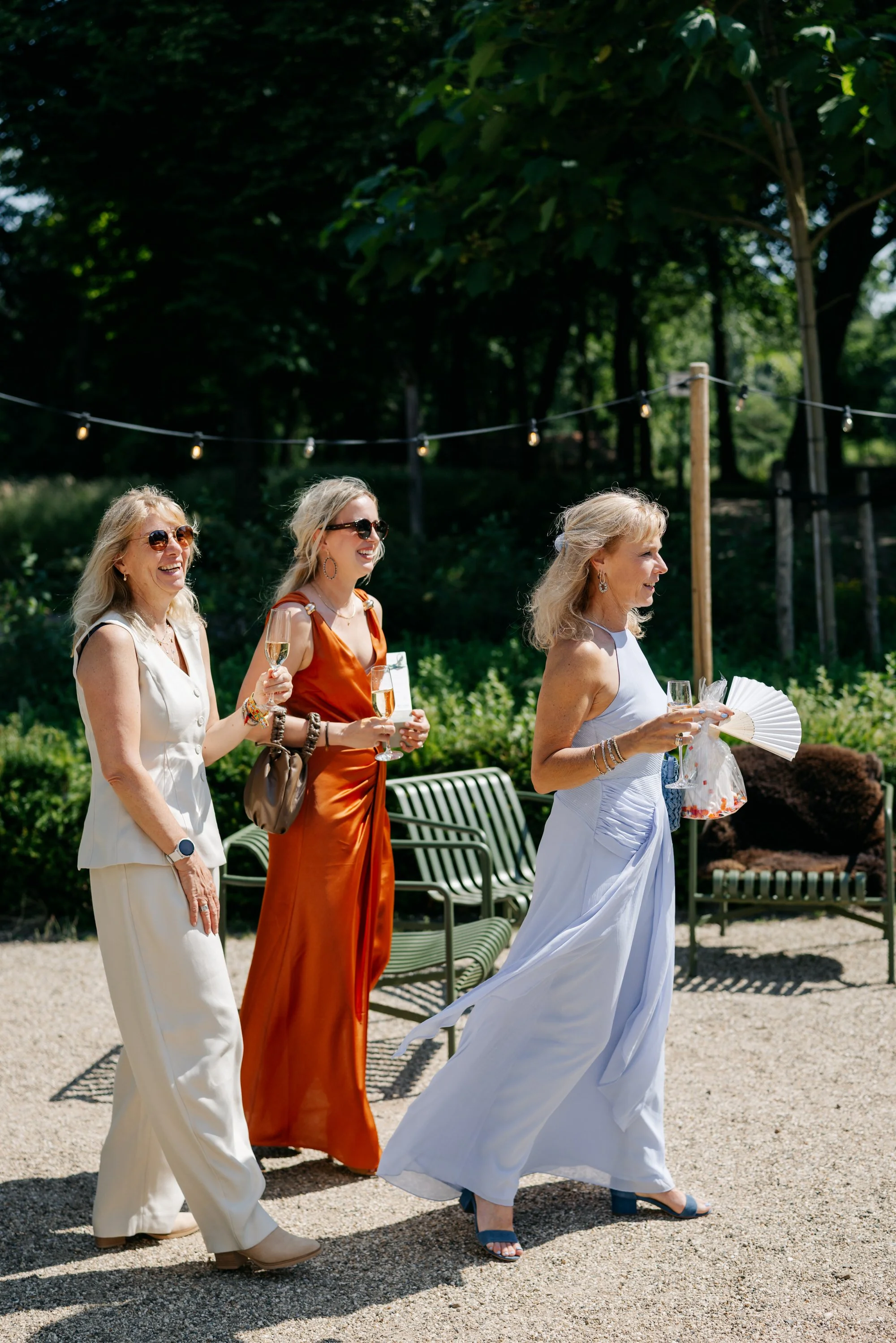  gasten lopen het terrein op voor de borrel op de trouwdag 