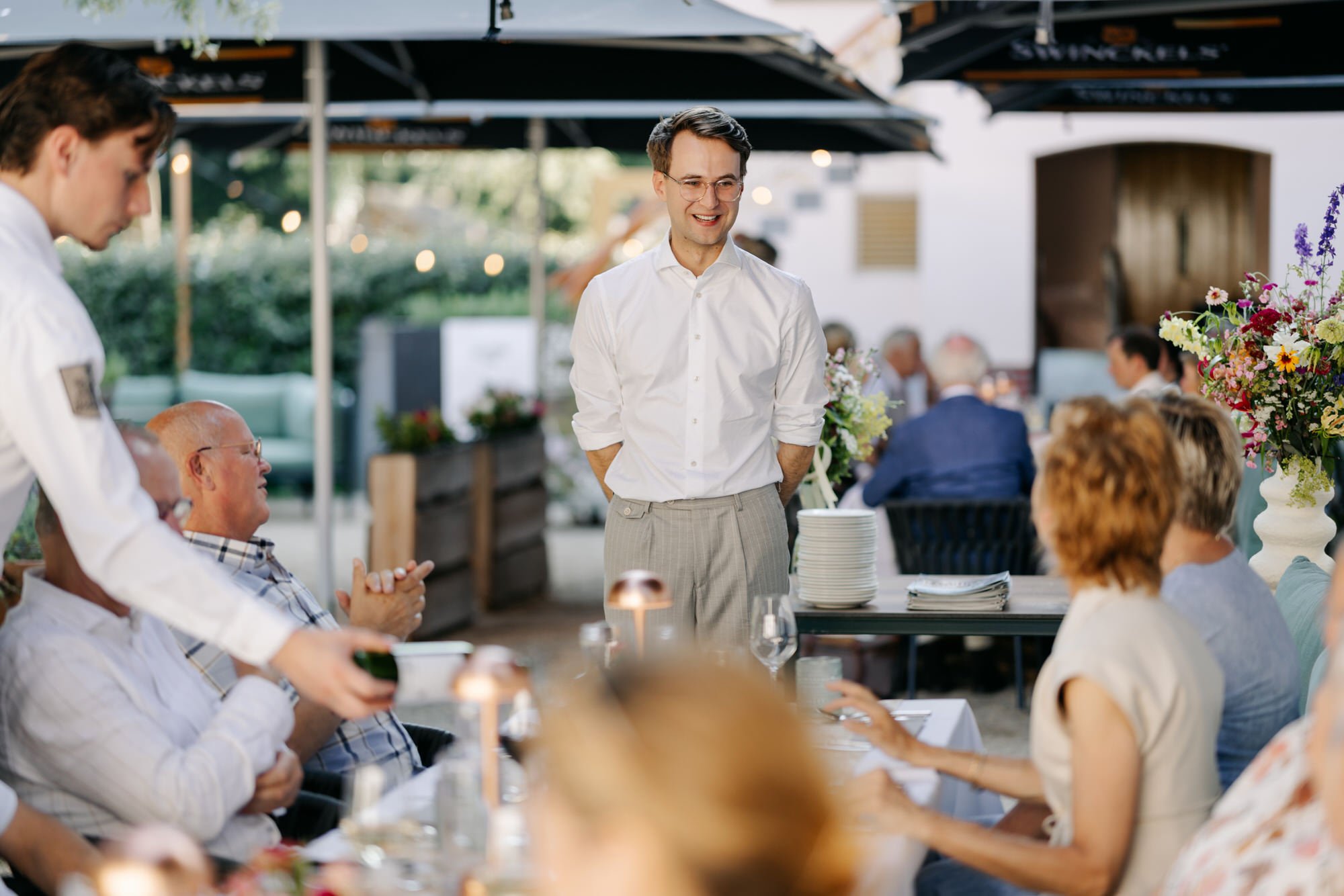  bruidegom praat met de gasten tijdens het diner 
