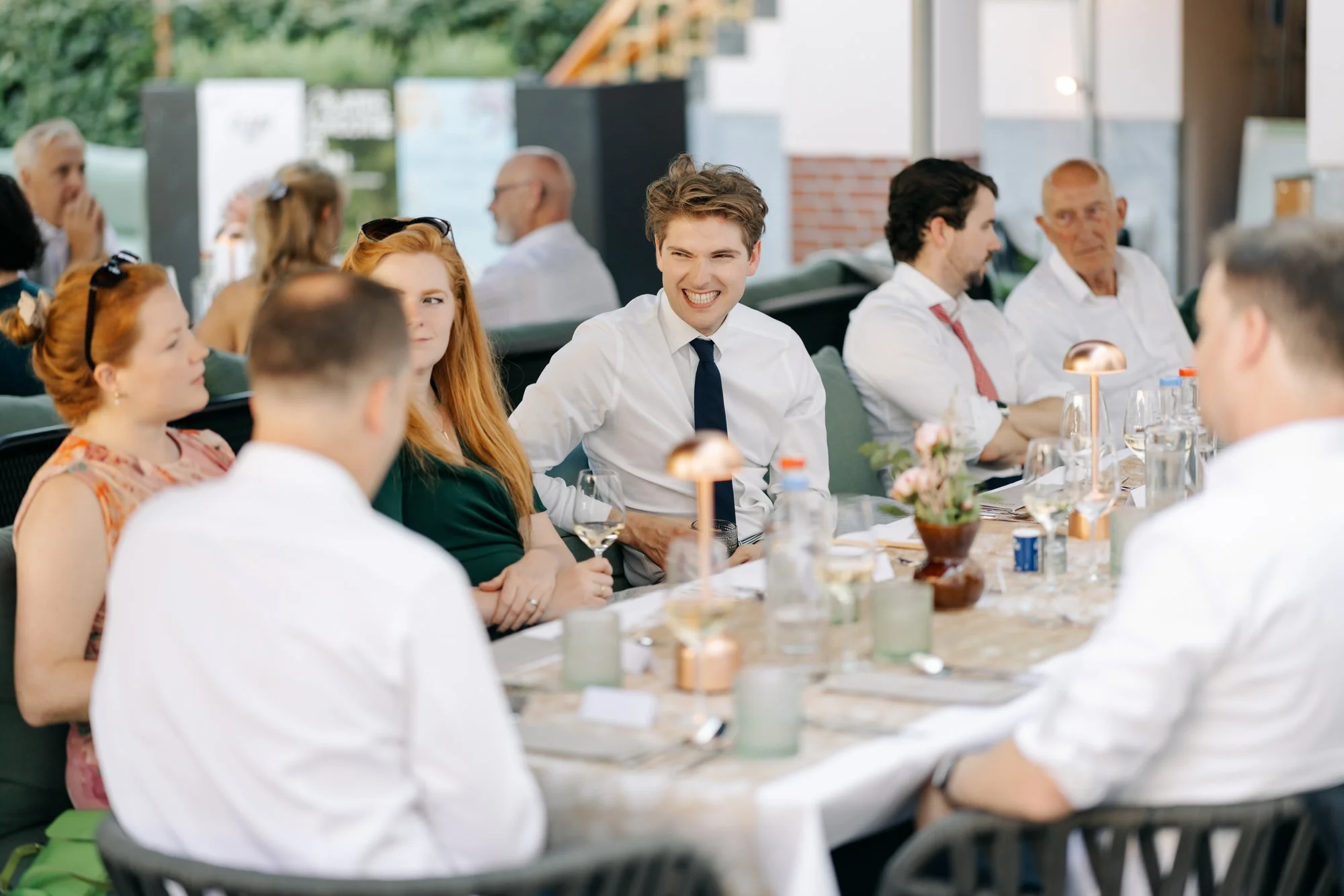  gasten aan de lange tafel tijdens het diner in de zomeravond 
