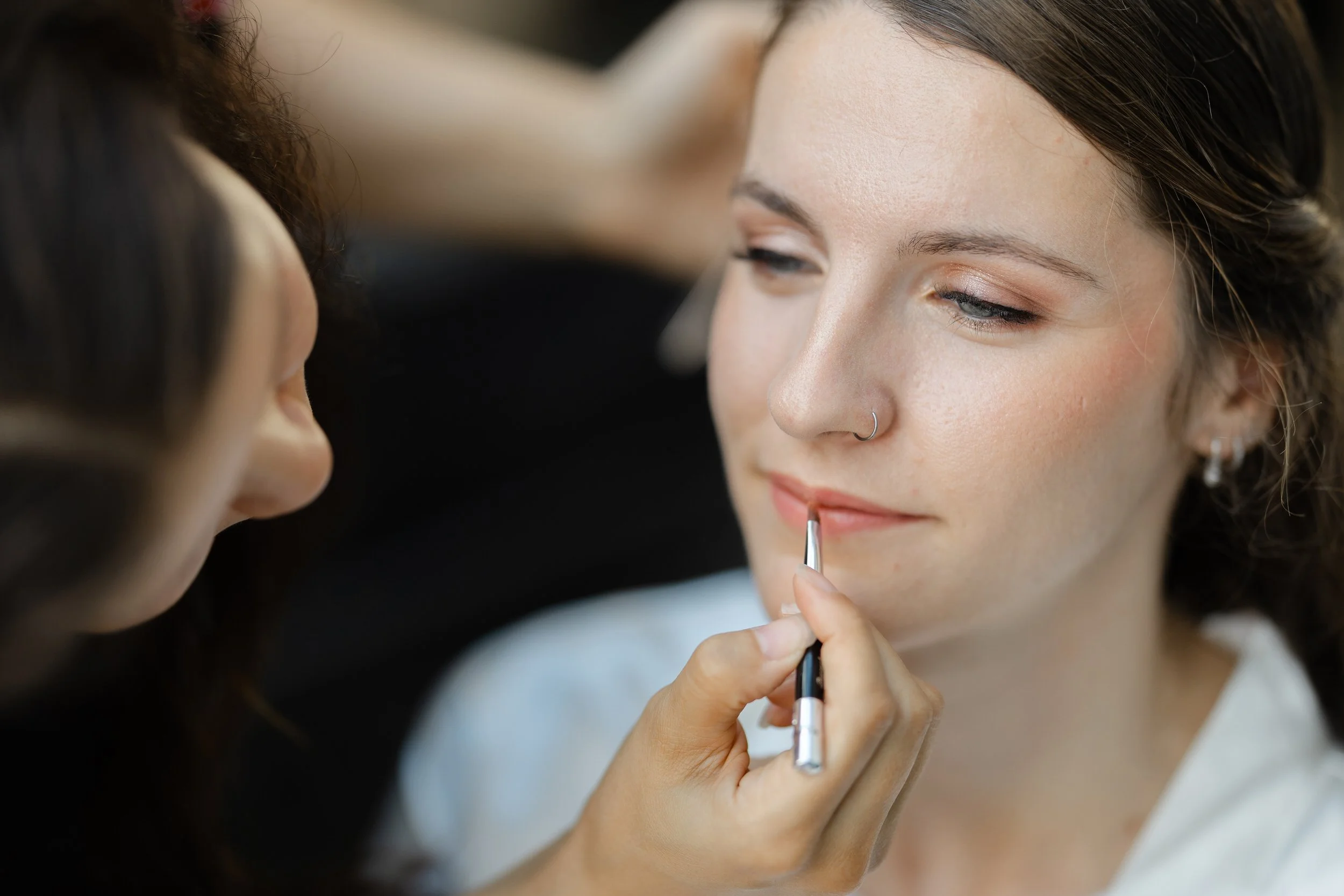 Bruid krijgt lipstick aangebracht tijdens de voorbereidingen, close up van een rustig moment op de trouwdag