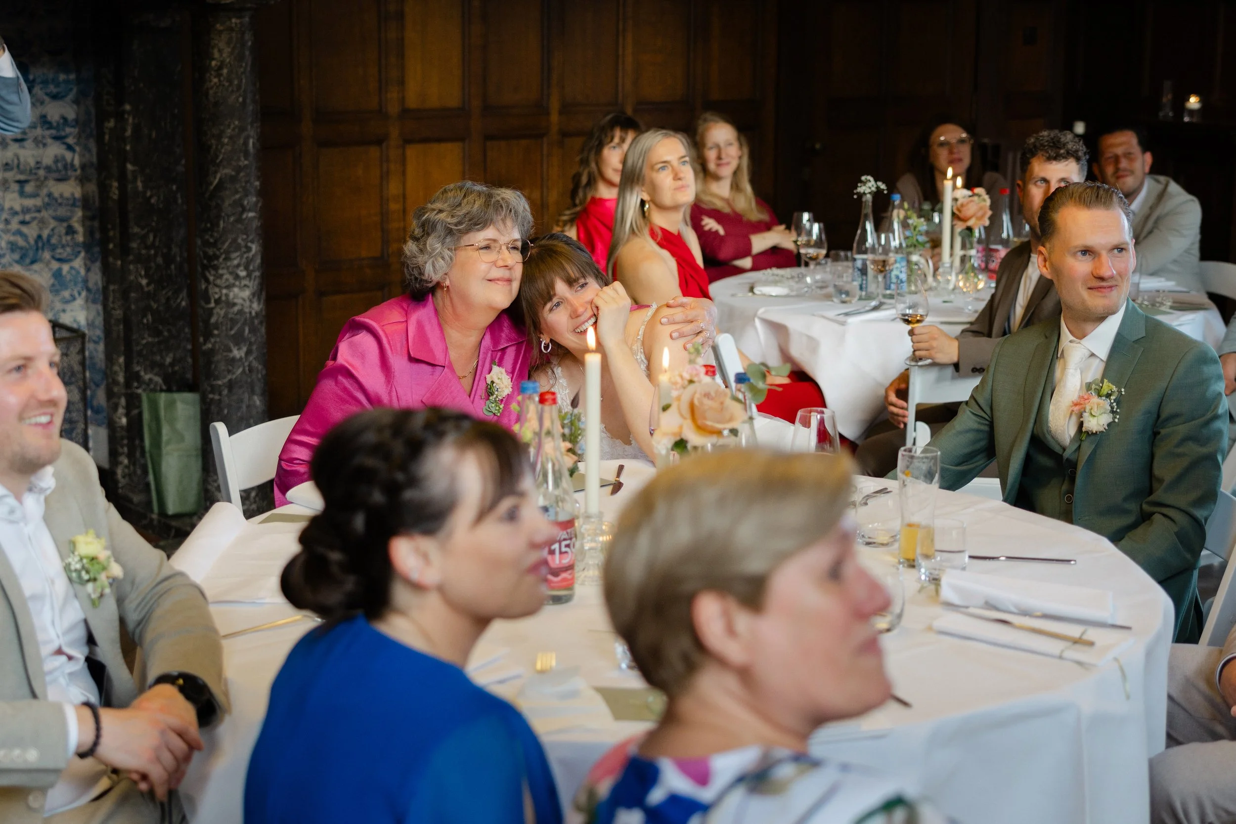 bruid en familie reageren emotioneel tijdens een speech aan tafel op hun bruiloft