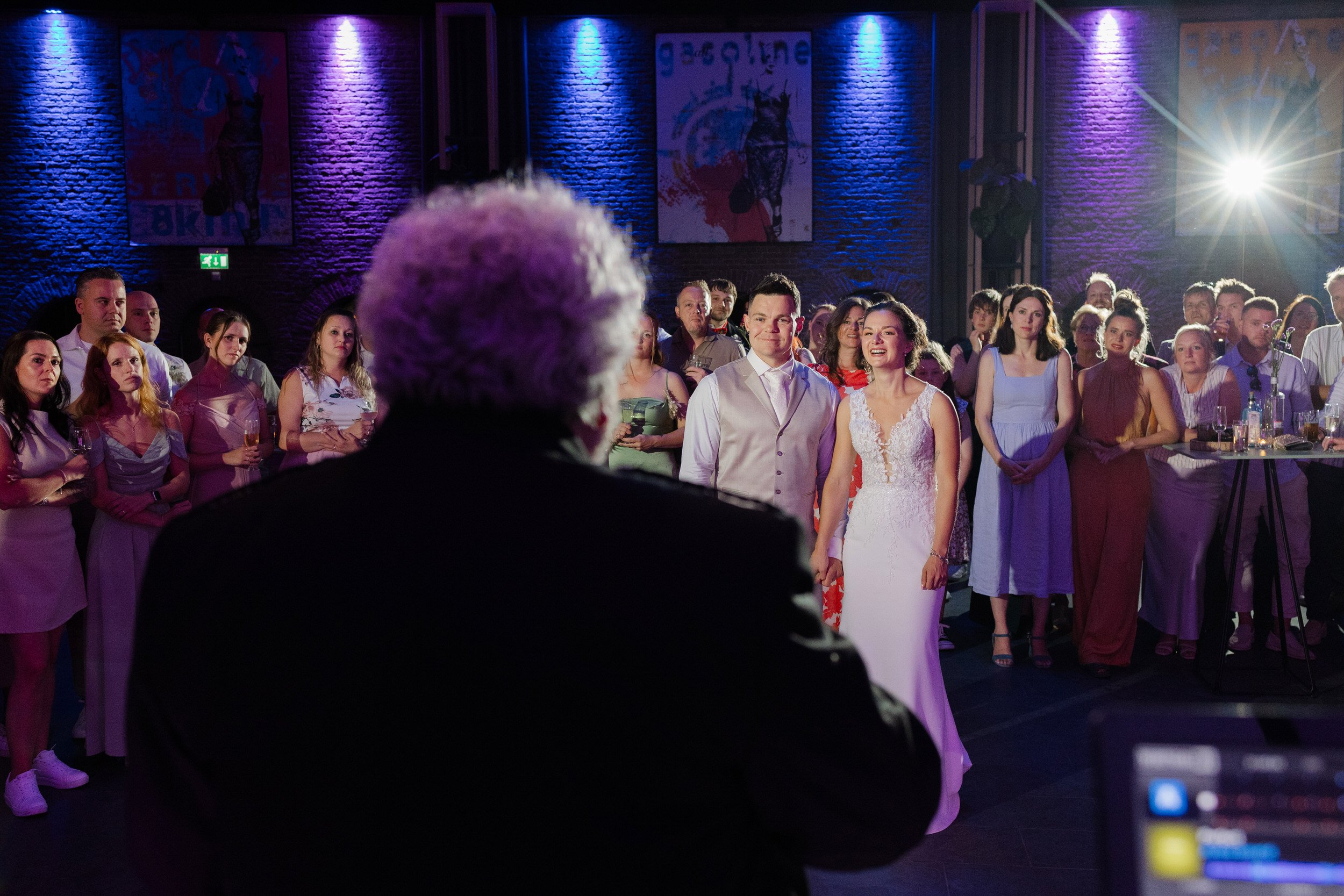 Gasten kijken toe tijdens een speech of optreden op het avondfeest van de bruiloft, reportagebeeld vol sfeer