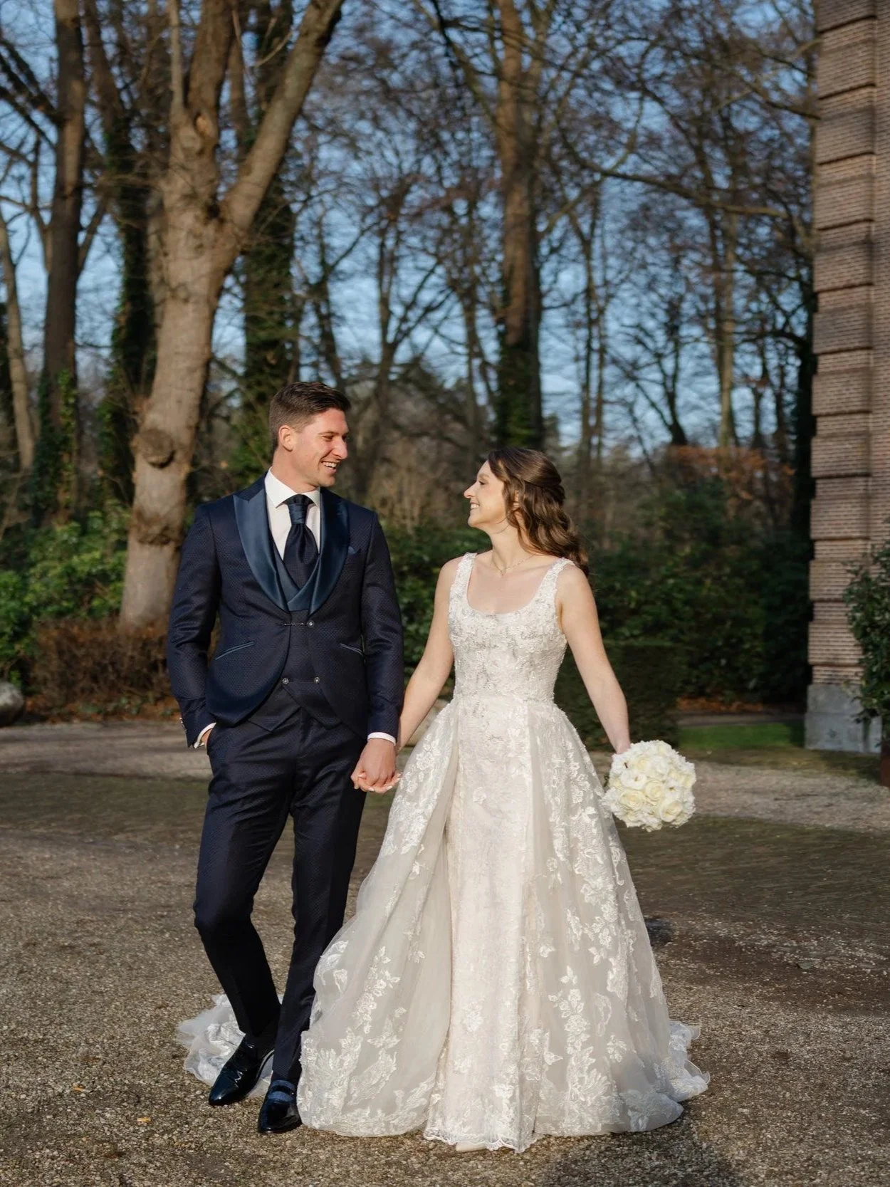 Bruidspaar loopt hand in hand tijdens een bruiloft bij Buitenplaats Sparrendaal