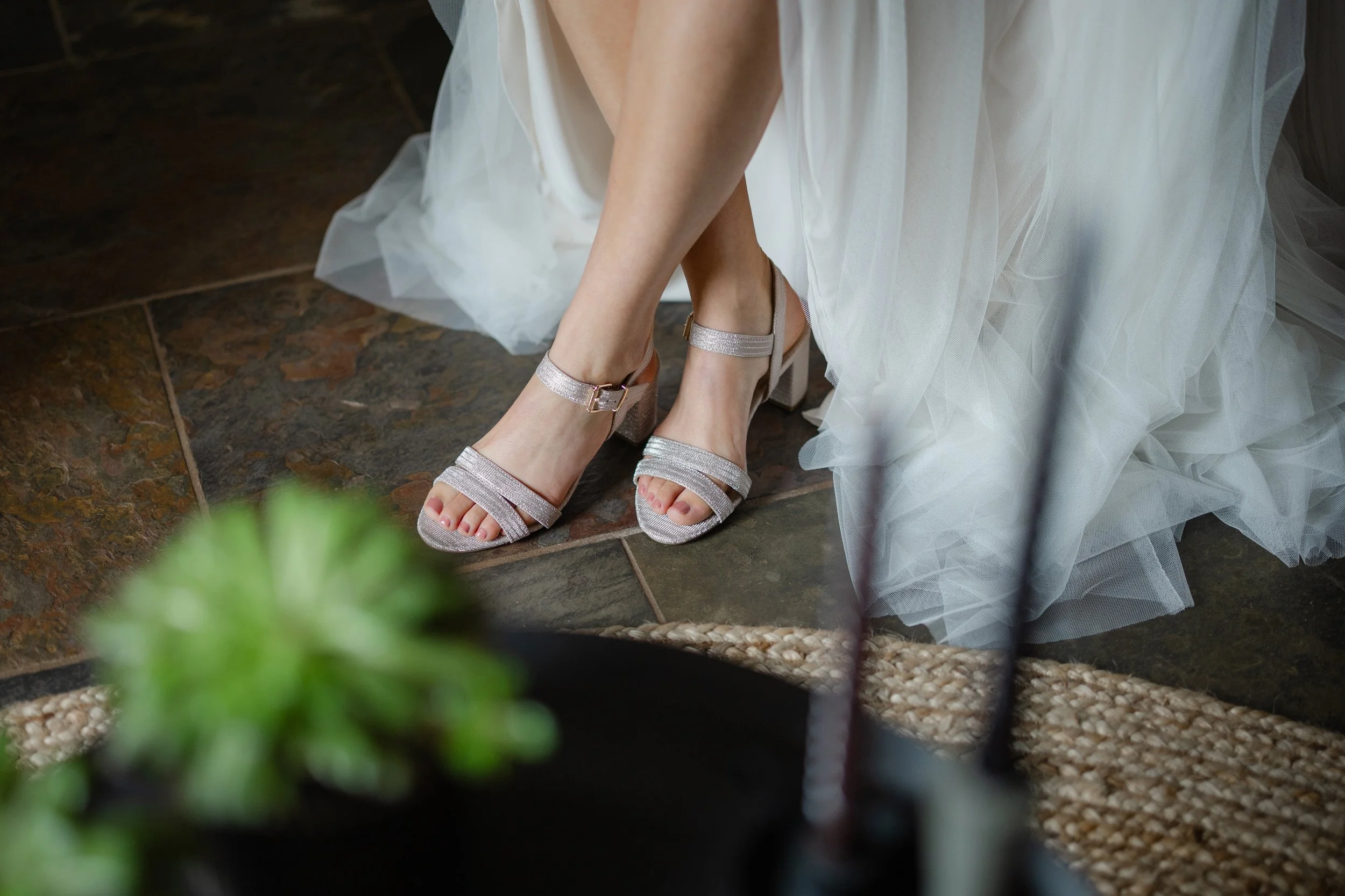 Close up van bruidsschoenen onder de jurk tijdens de voorbereidingen op de trouwdag