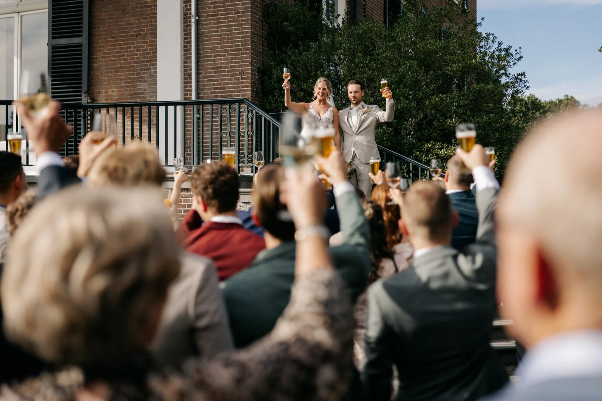 Bruidspaar proost met gasten tijdens receptie, bruiloft Landgoed Rhederoord
