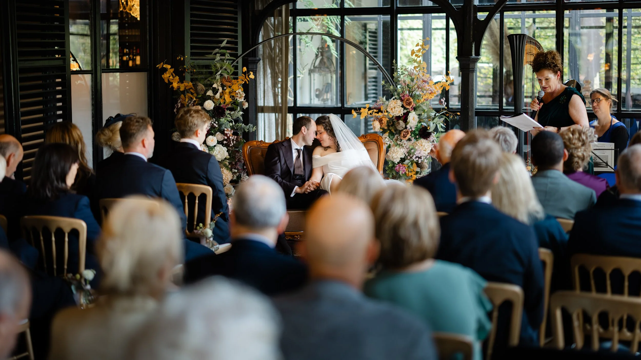 Ceremonie tijdens een binnenbruiloft met gasten en trouwambtenaar, reportagebeeld van een echt moment