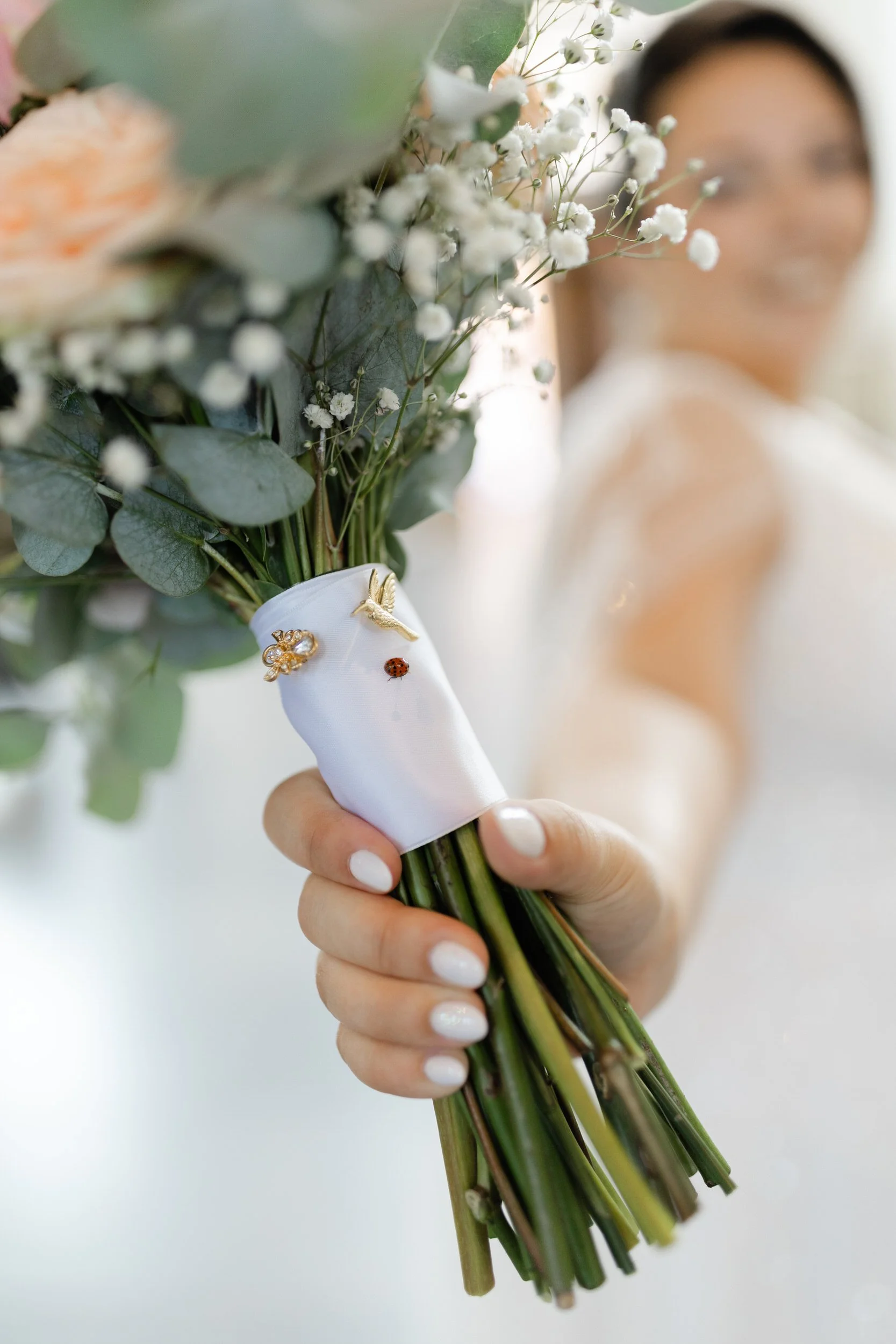 Close up van bruidsboeket met sieraden en details in de hand van de bruid, stijlvol detailbeeld van de trouwdag