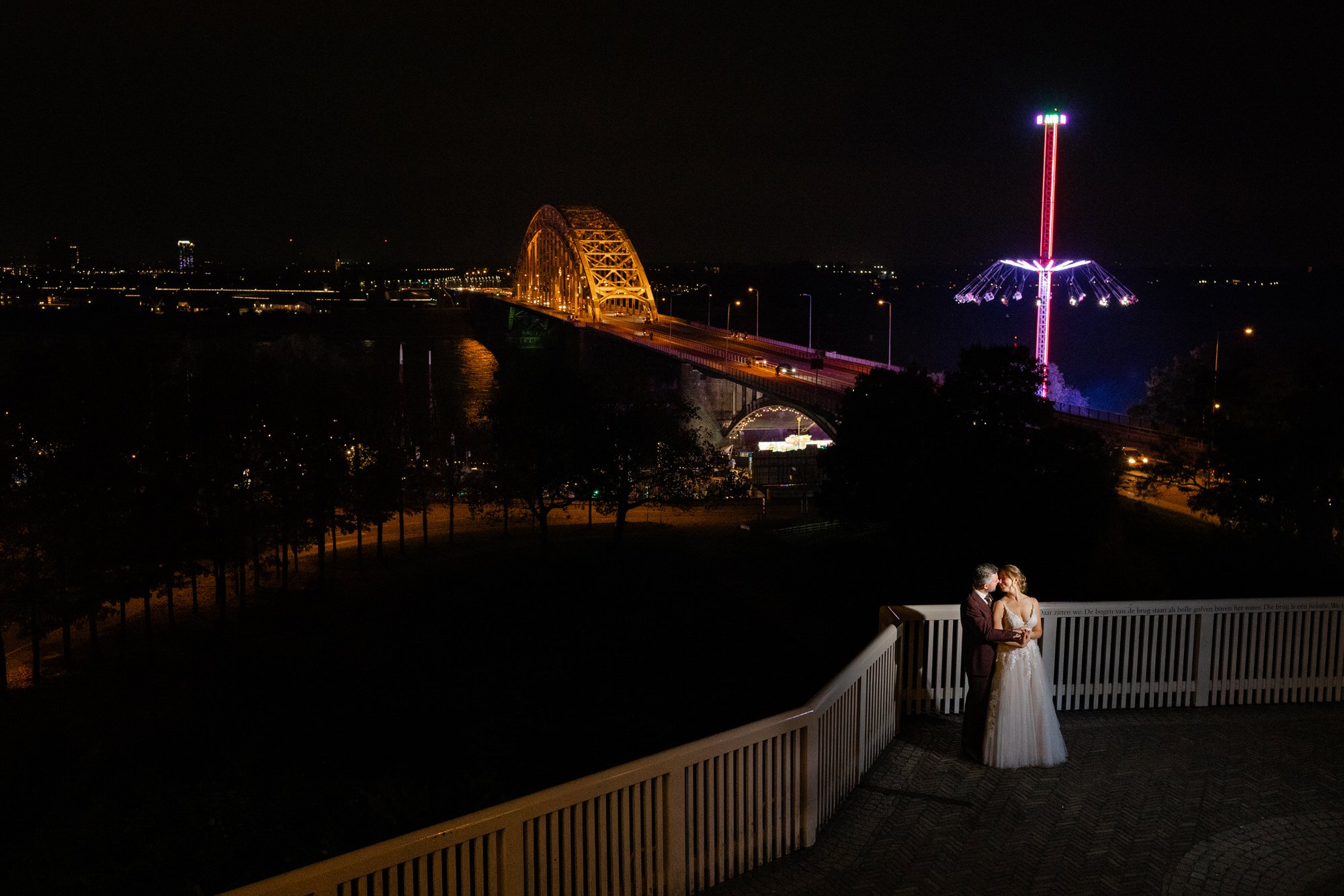 Avondfotoshoot van een bruidspaar met de Waalbrug in Nijmegen op de achtergrond