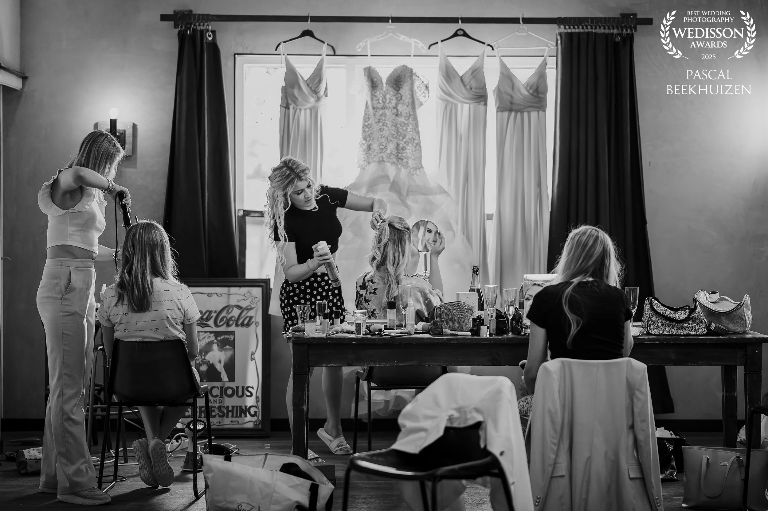 Bruid en bruidsmeisjes tijdens de voorbereidingen in zwart wit, award winnende trouwfoto met ontspannen sfeer
