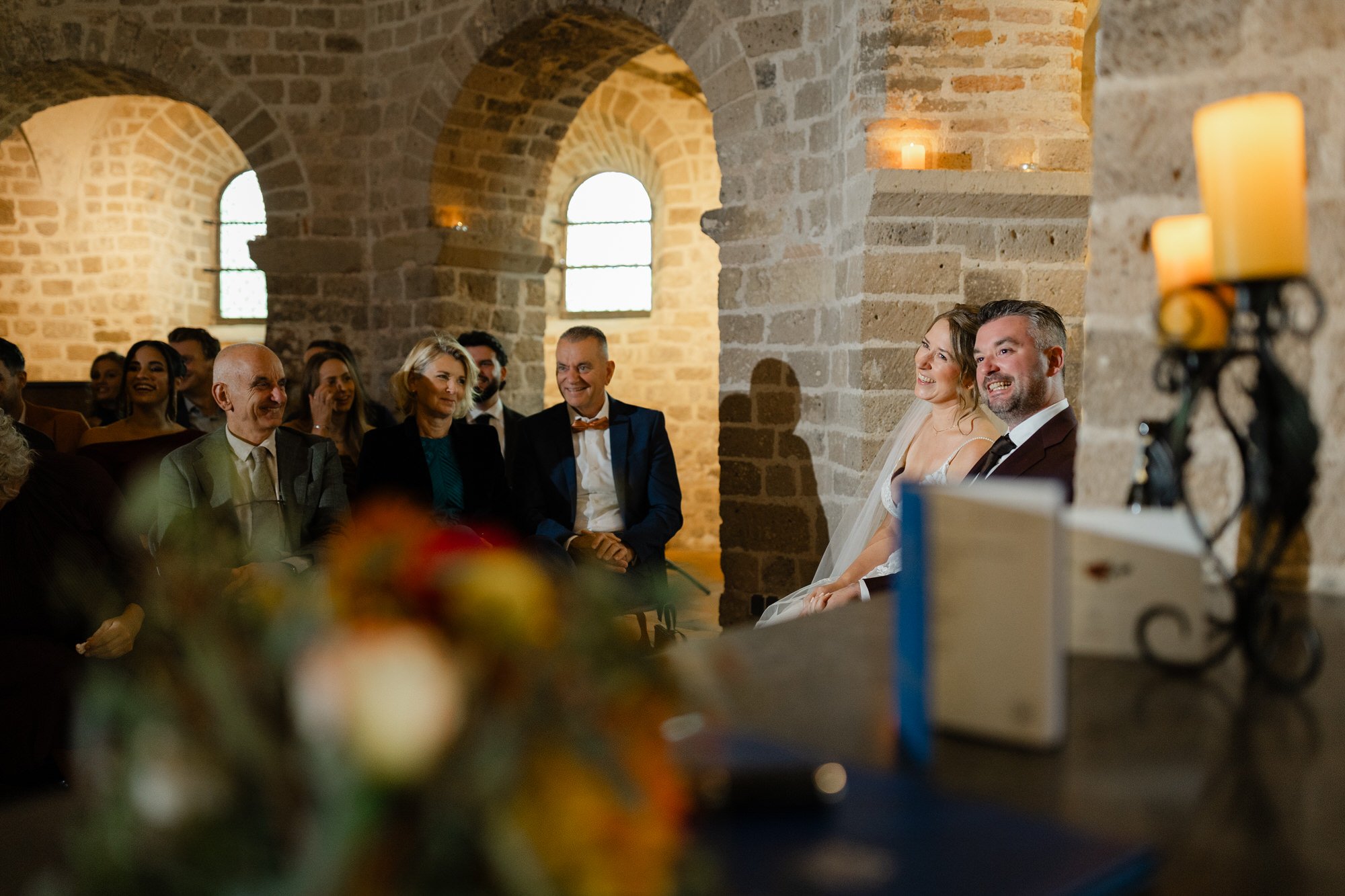 Bruidspaar tijdens de ceremonie in de Valkhofkapel in Nijmegen, omringd door gasten