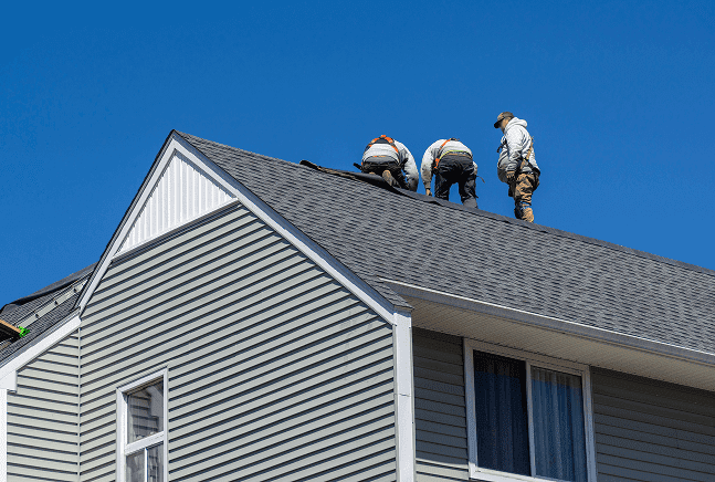 Team of contractors working on a house roof installation.