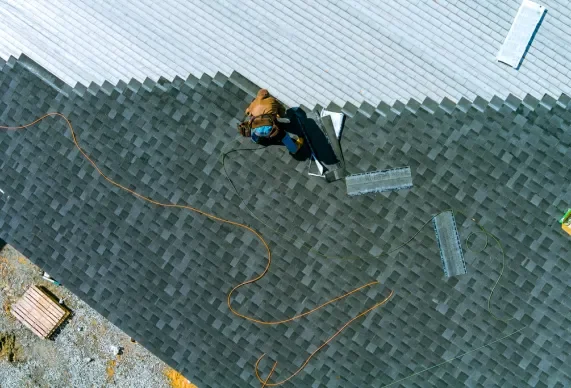 Aerial view of asphalt shingle installation on a roof.