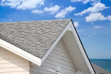 Gable roof with 3-tab shingles against a blue sky.
