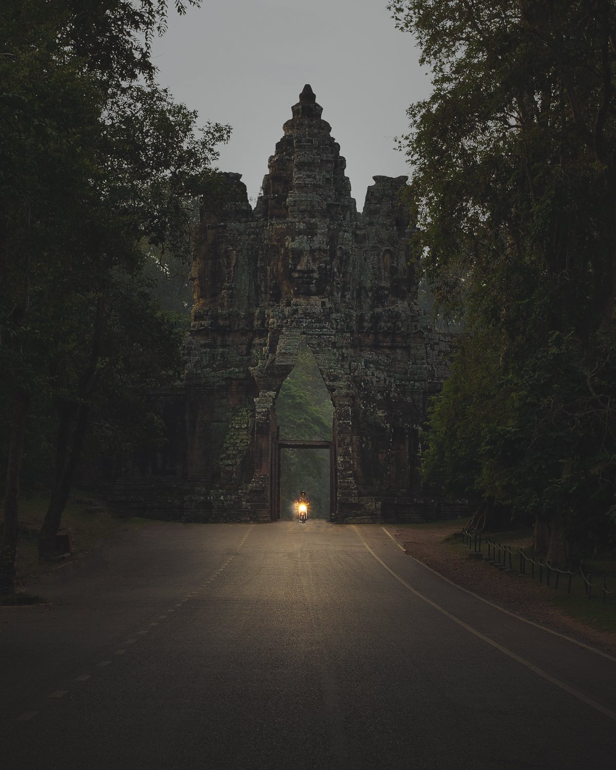 Motorcyclist riding through the Angkor Wat gate.