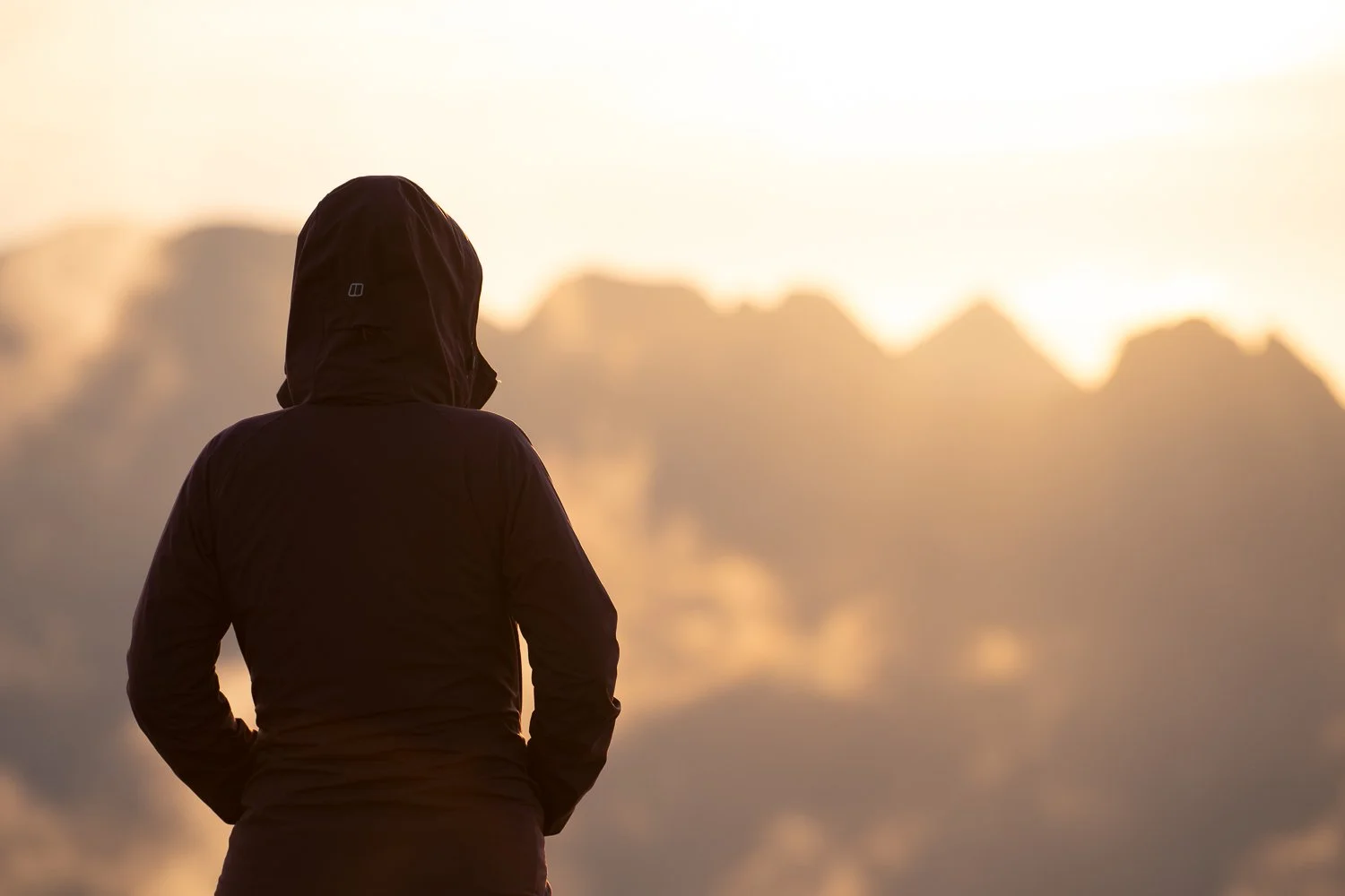 Silhouette of a person watching sun setting behind Cullin Mountains on Skye.