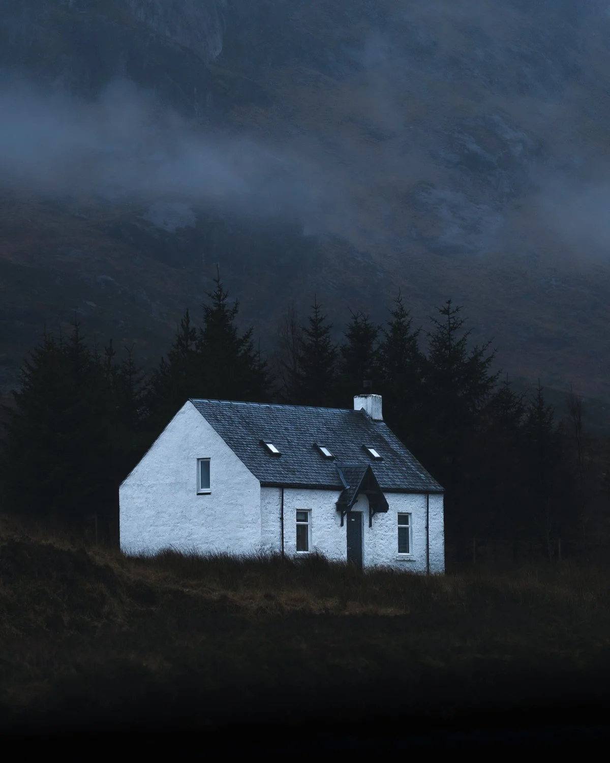 Moody and misty evening by the Glen Coe's white cottage.